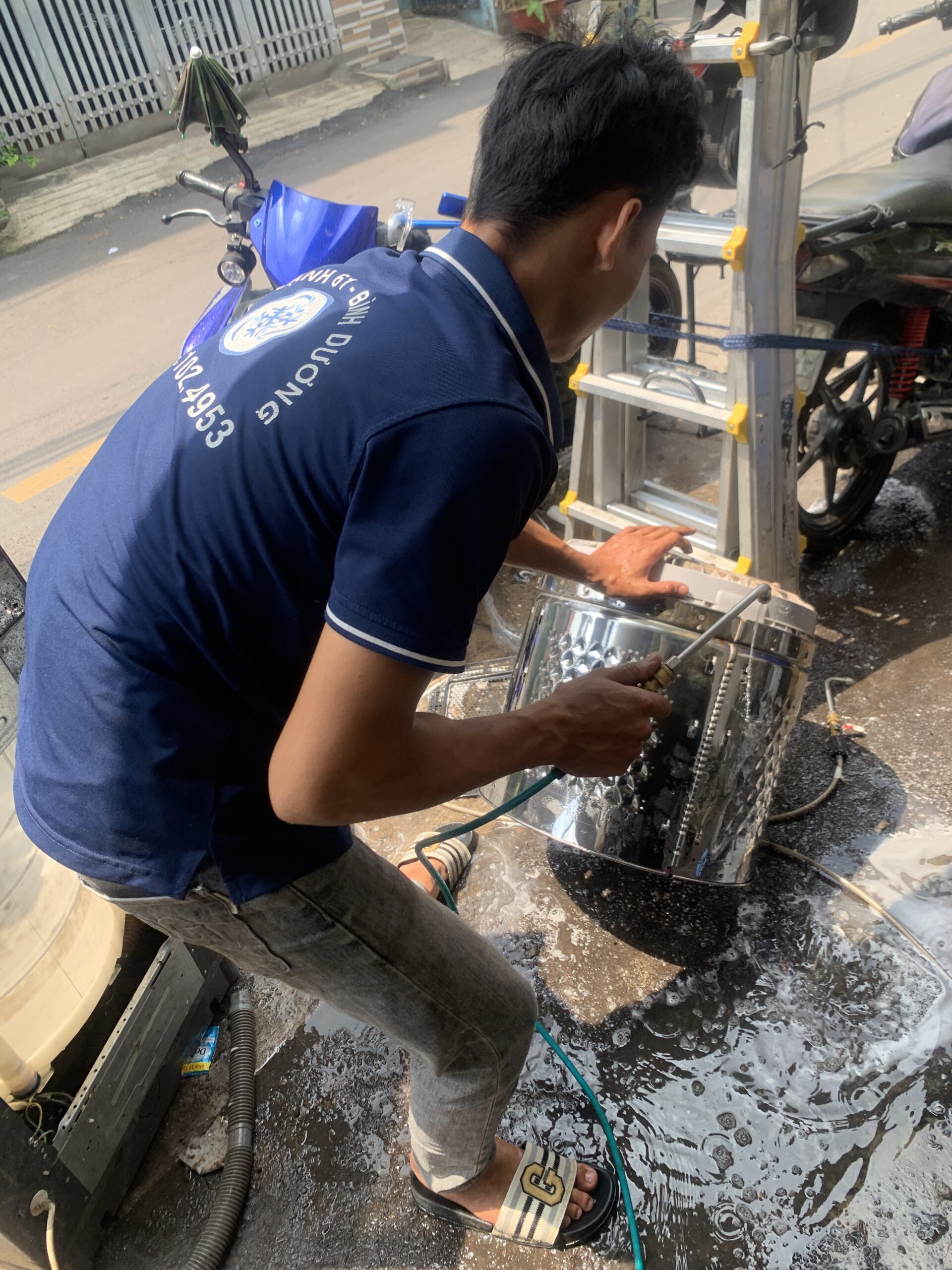 Dùng máy bơm áp lực cao xịt rửa cặn bẩn mảng bám trên lồng inox máy giặt