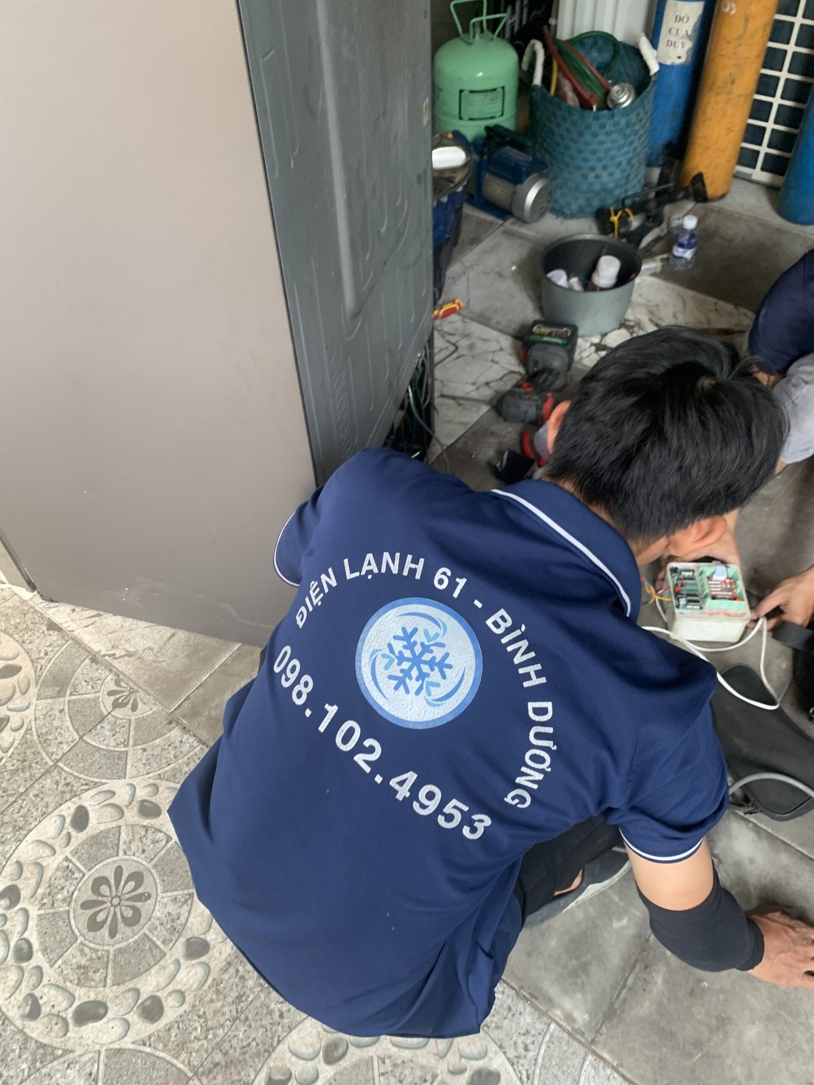 Hình ảnh kỹ thuật viên Điện Lạnh 61 kiểm tra hệ thống xả đá của tủ lạnh tại Dĩ An.