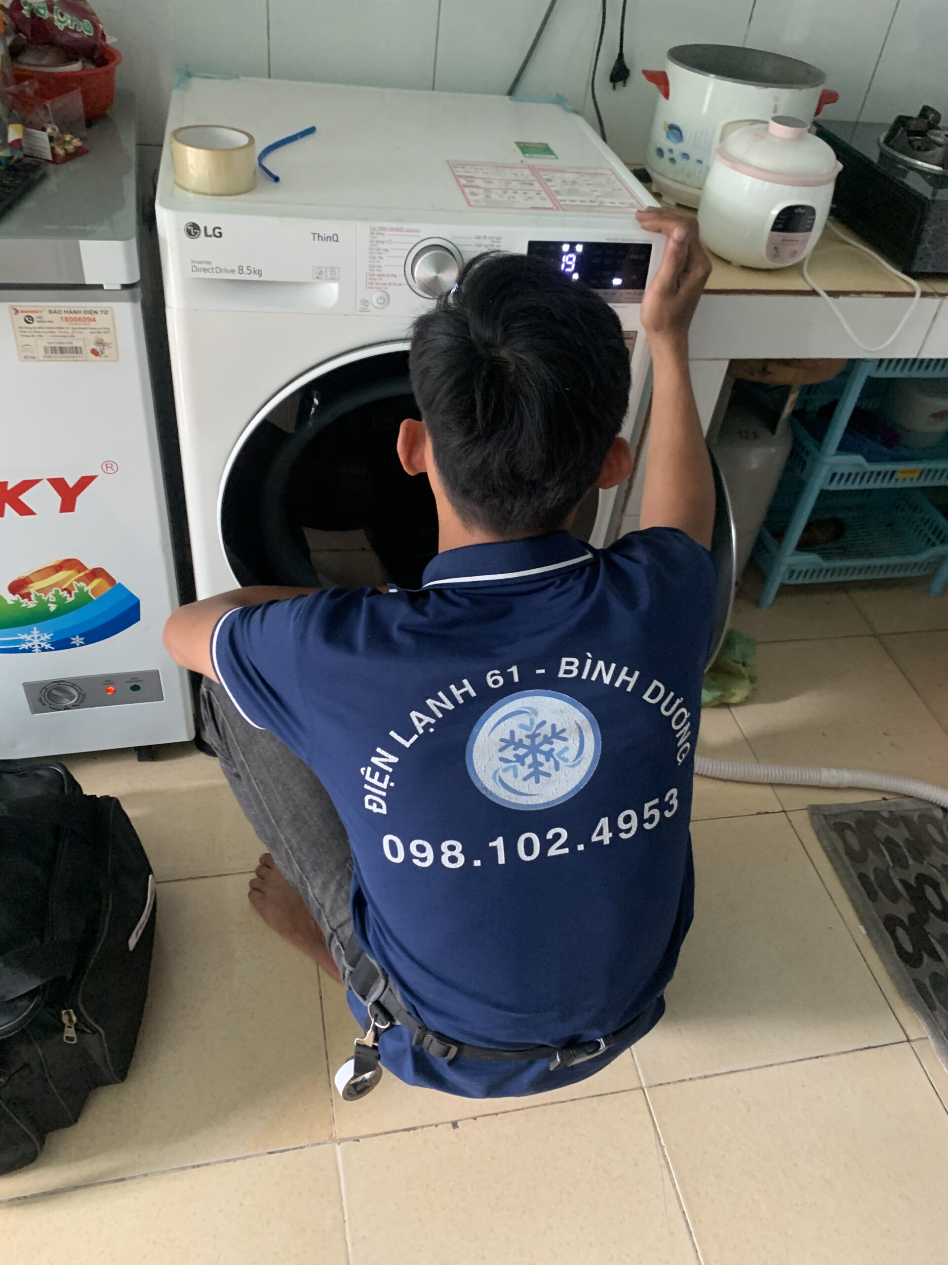 Kỹ thuật viên Điện Lạnh 61 đang kiểm tra lỗi máy giặt không vắt tại nhà khách ở Dĩ An.