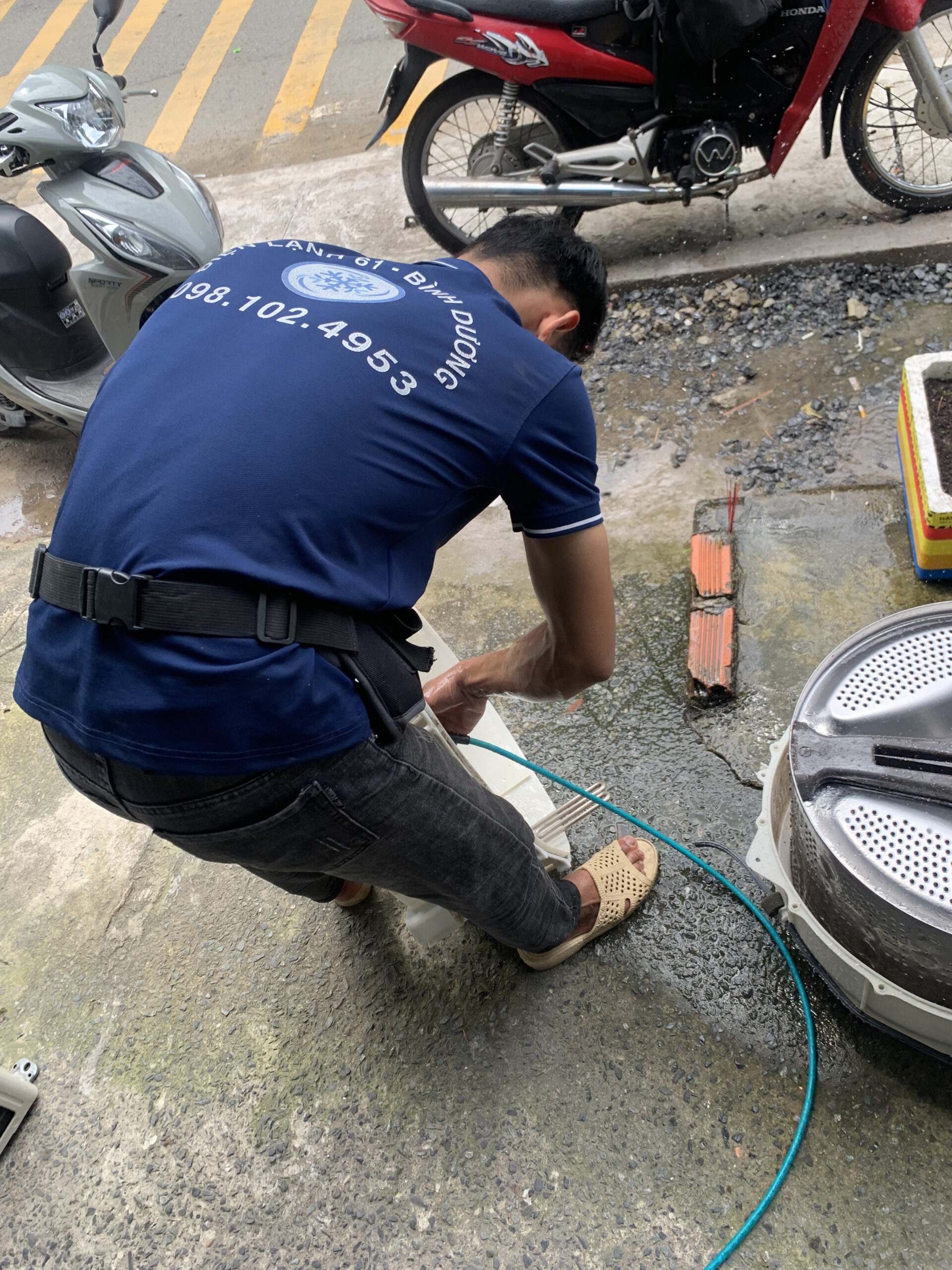 Kỹ thuật viên Điện Lạnh 61 đang tháo rời lồng giặt để vệ sinh sâu tại Thuận An