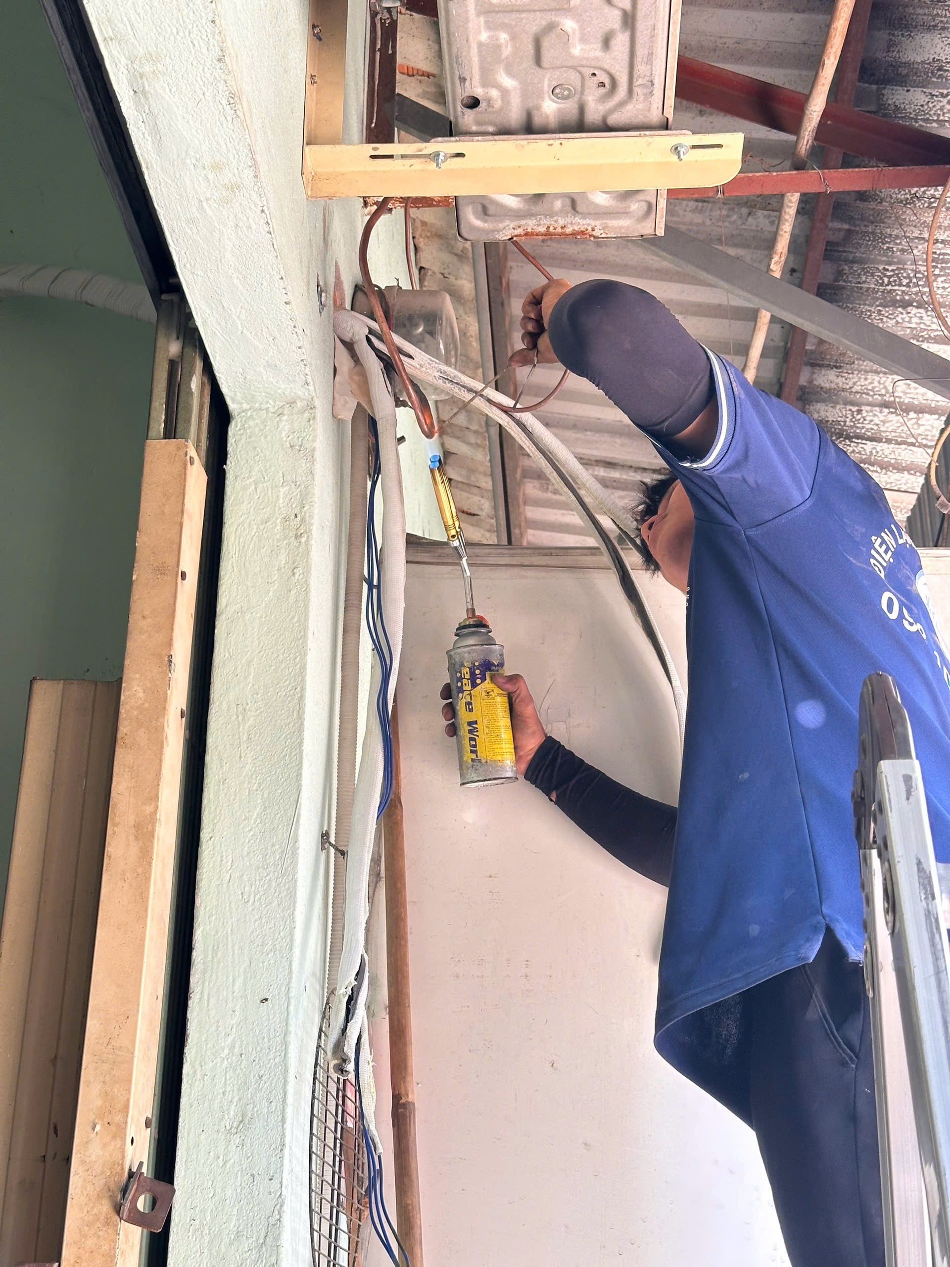 Kỹ thuật viên đang nạp gas máy lạnh đúng chuẩn, dịch vụ sửa máy lạnh tại Dĩ An chuyên nghiệp