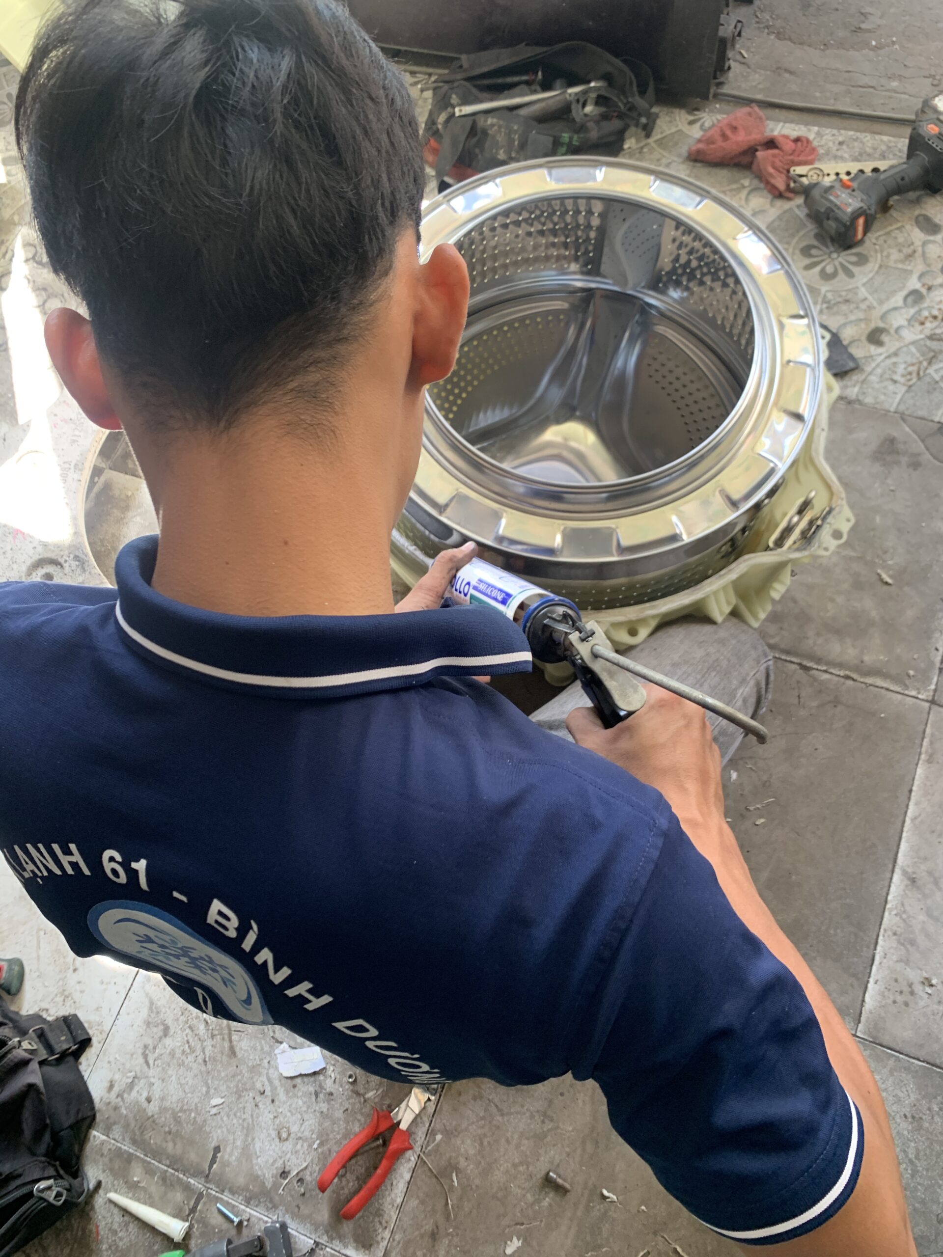 Quy trình tháo lồng vệ sinh máy giặt lồng ngang cửa trước tại Dĩ An