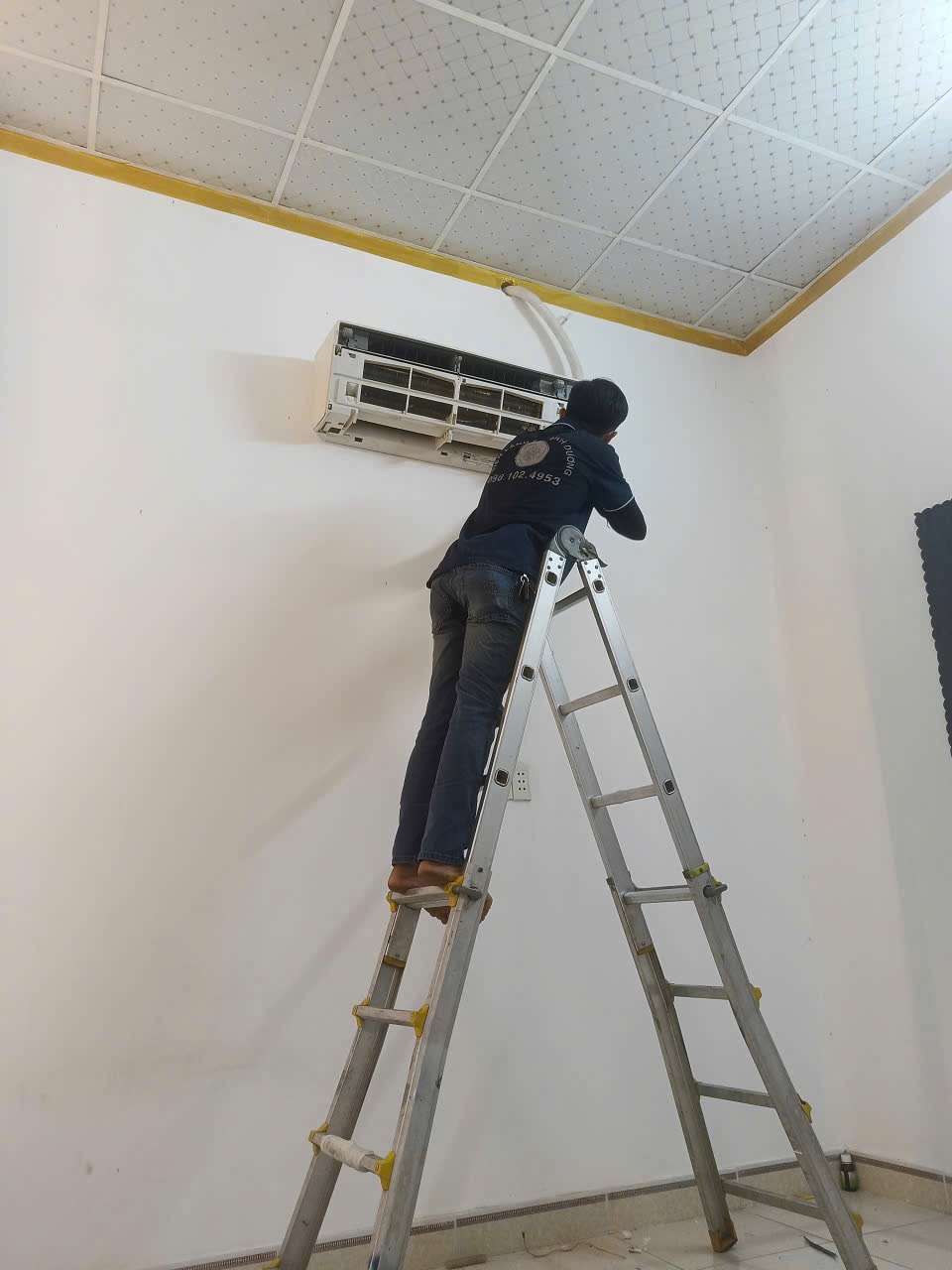 Thợ rửa máy lạnh tại Thuận An dùng khăn bọc kín bo mạch điện tử để đảm bảo an toàn.