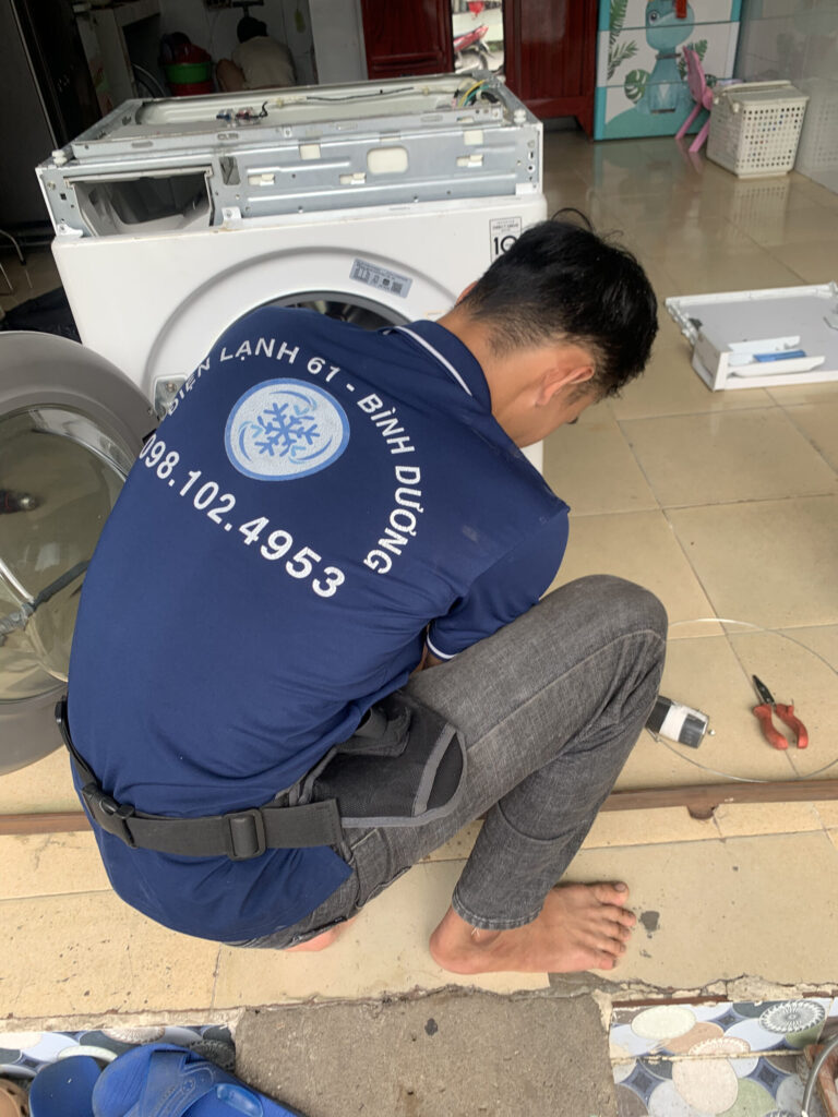 Thợ sửa máy giặt Thuận An của Điện Lạnh 61 đang kiểm tra mâm giặt tại nhà khách hàng.