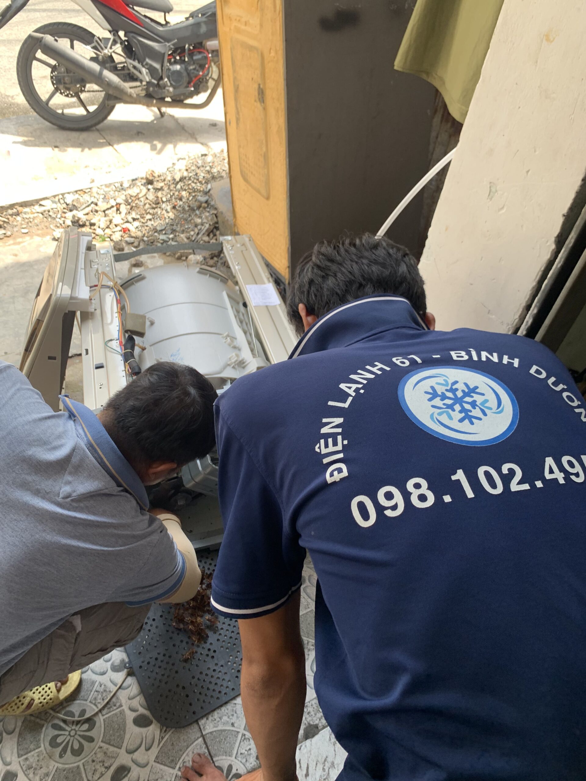 Thợ đang tháo rời lồng giặt cửa trên