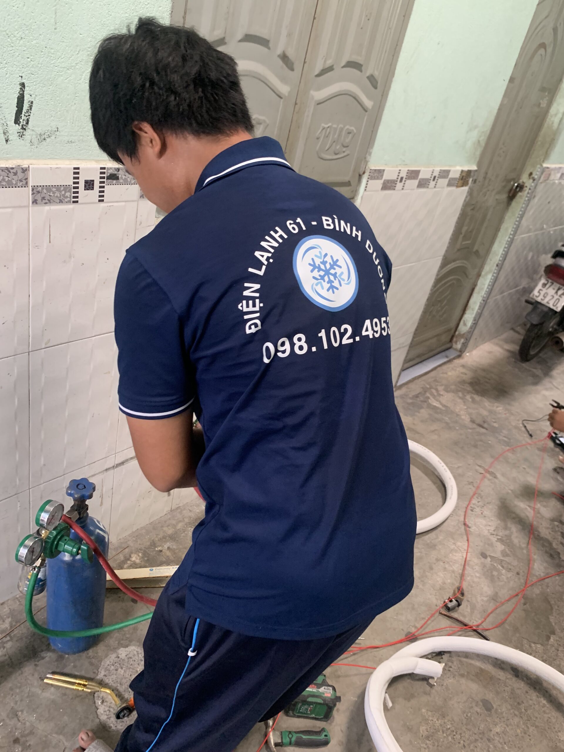 Kỹ thuật viên chuyên nghiệp đang kiểm tra và sửa máy lạnh tại nhà ở Tân Uyên