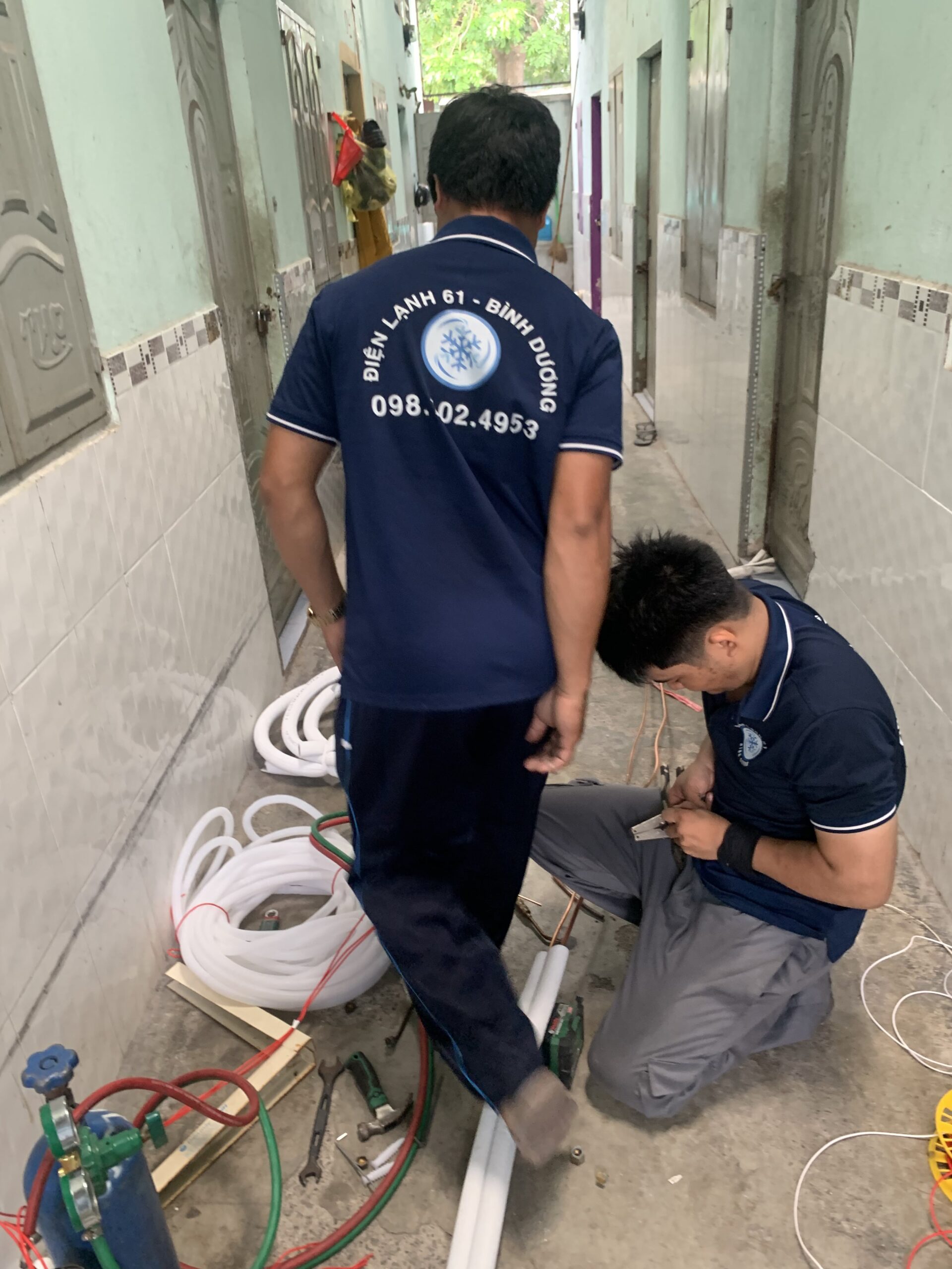 Kỹ thuật viên đang kiểm tra máy lạnh sau khi lắp đặt tại Bình Dương