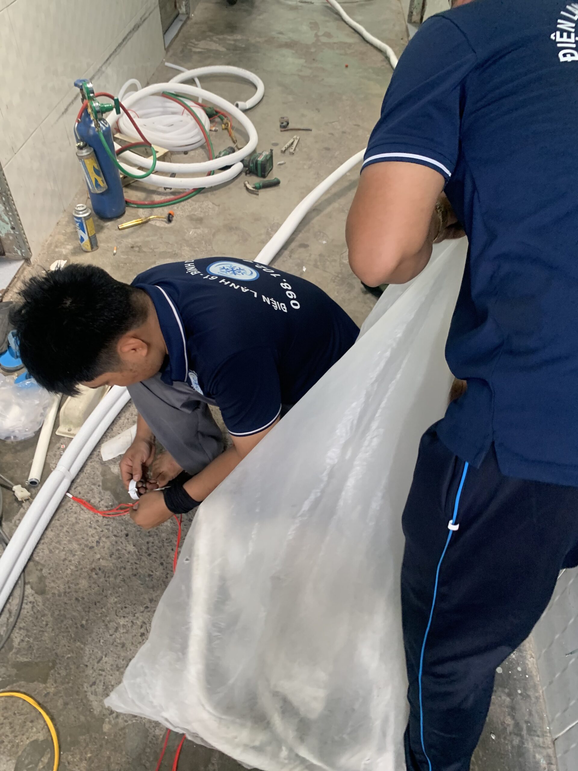 Ky-thuat-vien-dang-ve-sinh-may-lanh-cho-khach-hang-tai-Tan-Uyen-Binh-Duong Kỹ thuật viên đang vệ sinh máy lạnh cho khách hàng tại Tân Uyên Bình Dương