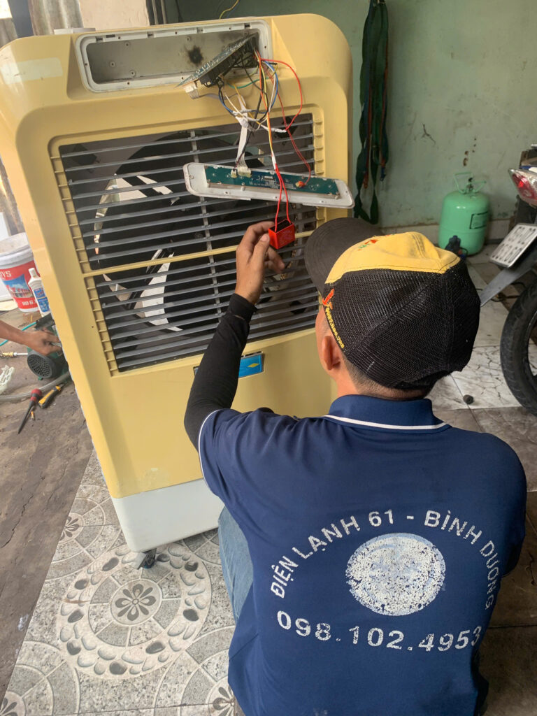 Kỹ thuật viên kiểm tra bo mạch quạt hơi nước tại nhà khách hàng ở Dĩ An