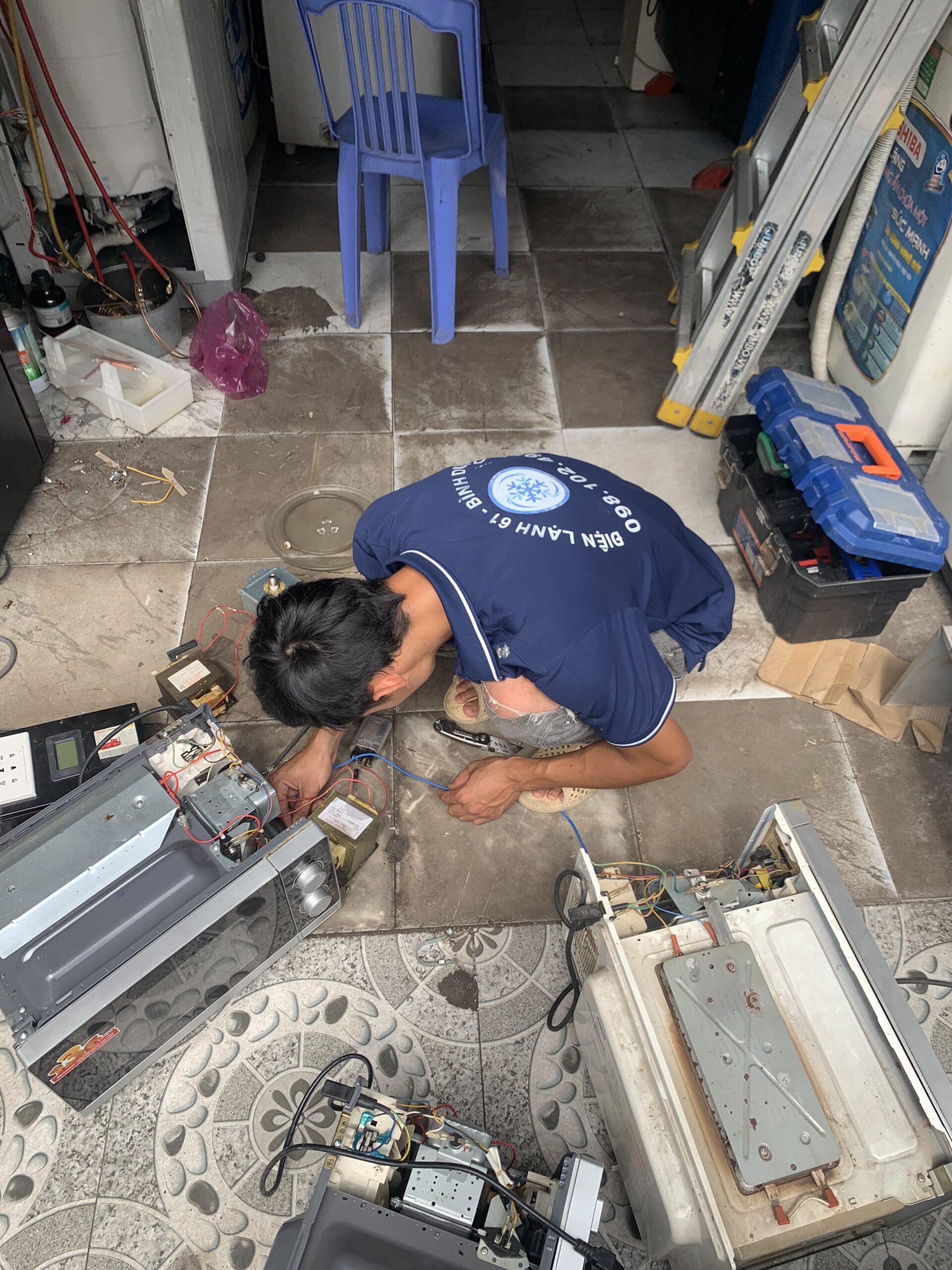 Thợ kỹ thuật đang thay thế linh kiện lò vi sóng chính hãng tại Dĩ An.