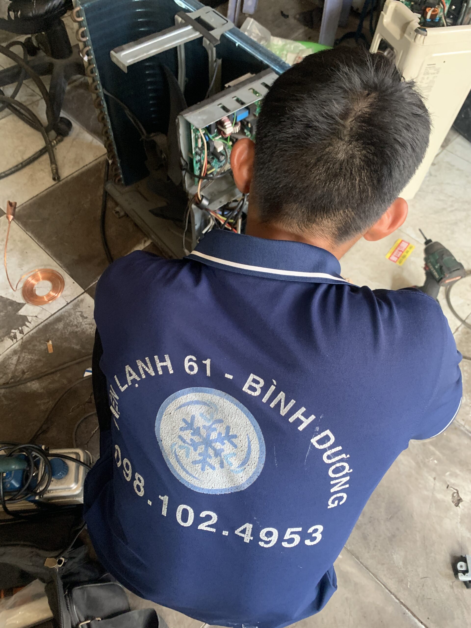 Thợ sửa máy lạnh tại Tân Uyên của Điện Lạnh 61 đang kiểm tra board mạch
