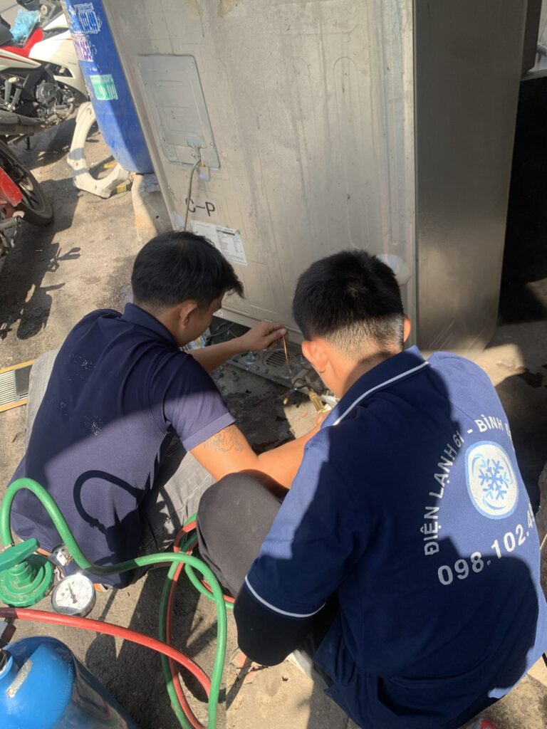 Thợ sửa tủ lạnh tại Bình Dương của Điện Lạnh 61 đang kiểm tra lỗi không lạnh