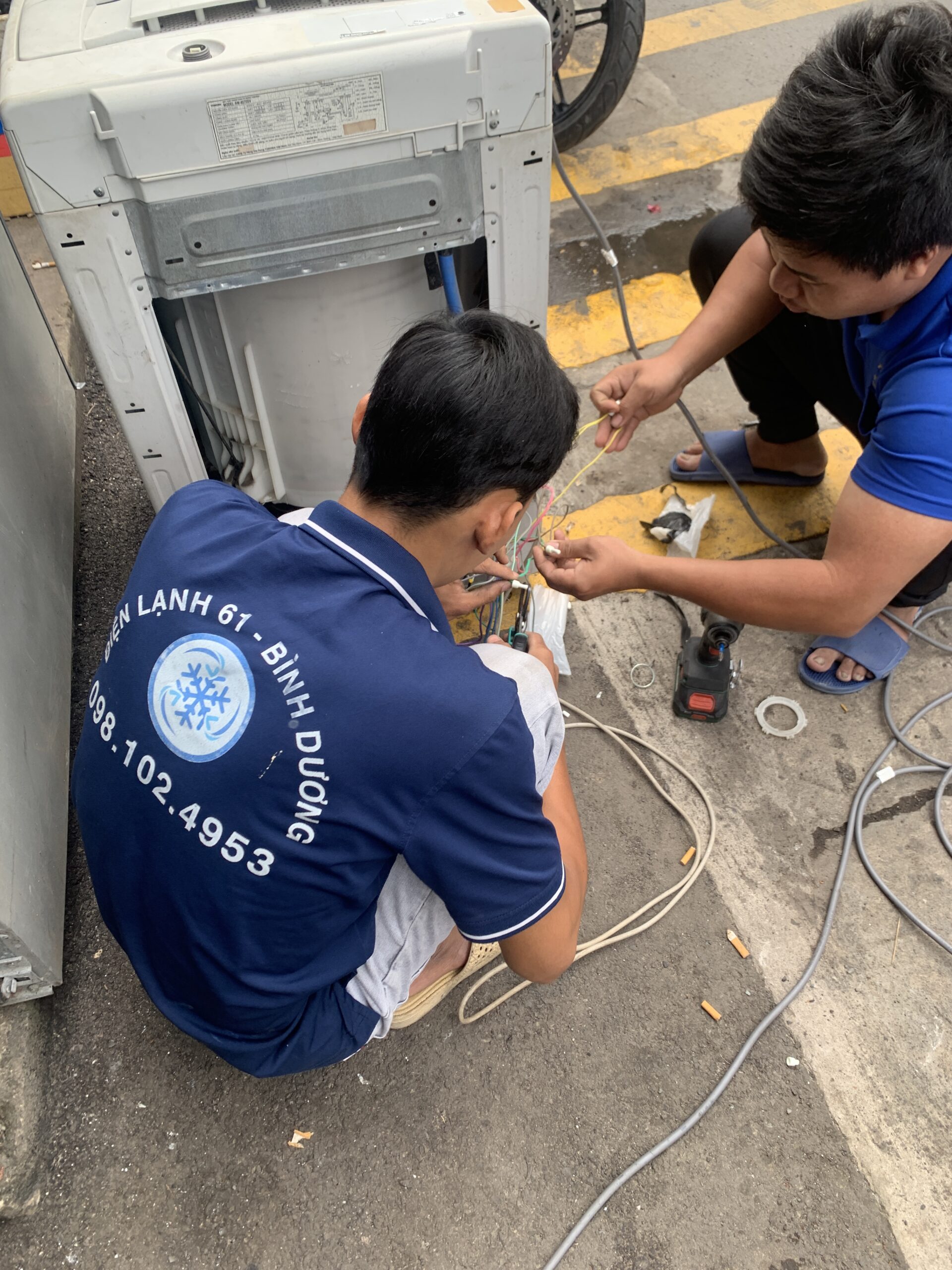 Kỹ thuật viên đang kiểm tra máy giặt cửa trên