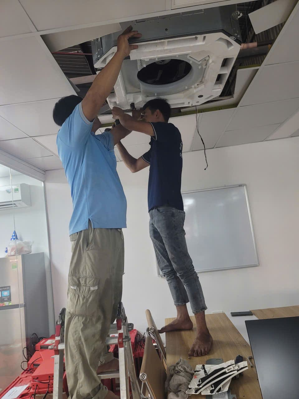 Ky-thuat-vien-dang-ve-sinh-may-lanh-tai-Tan-Dong-Hiep-lam-sach-bui-ban-luoi-loc Kỹ thuật viên đang vệ sinh máy lạnh tại Tân Đông Hiệp, làm sạch bụi bẩn lưới lọc.