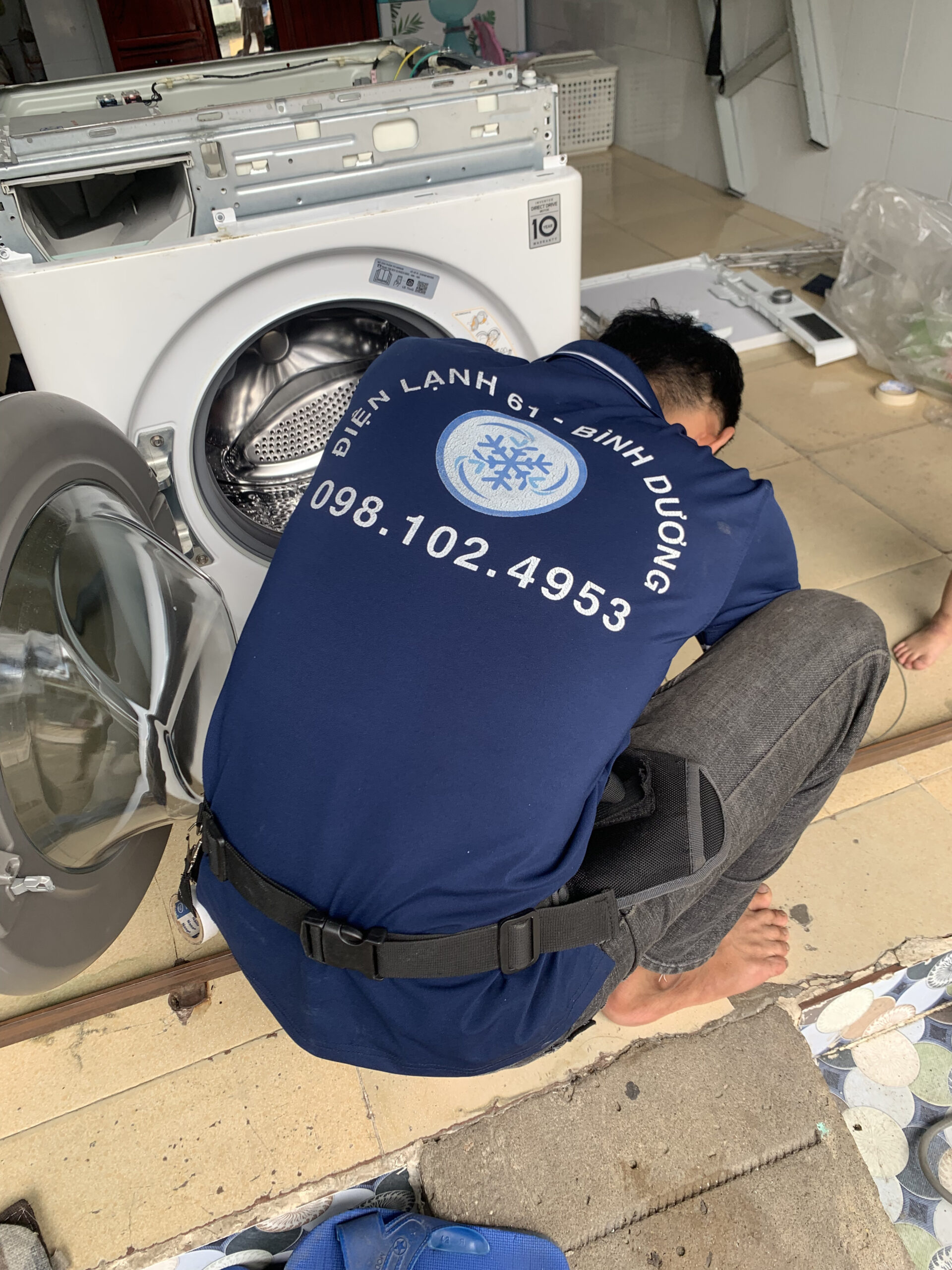 Thợ Điện Lạnh 61 vệ sinh kỹ lưới lọc xơ vải và khay chứa nước xả của máy giặt lồng ngang.