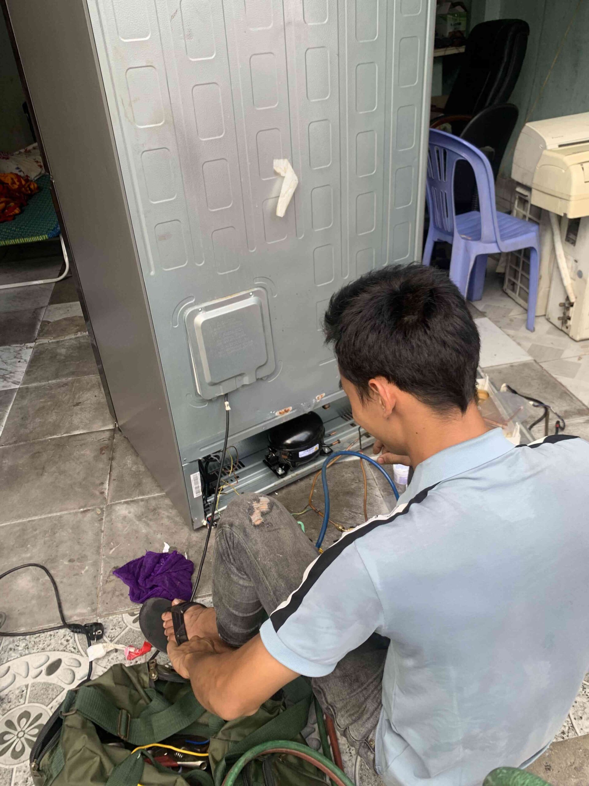 Thợ kỹ thuật Điện Lạnh 61 đang kiểm tra và sửa chữa tủ lạnh Đông Hòa tại nhà khách hàng