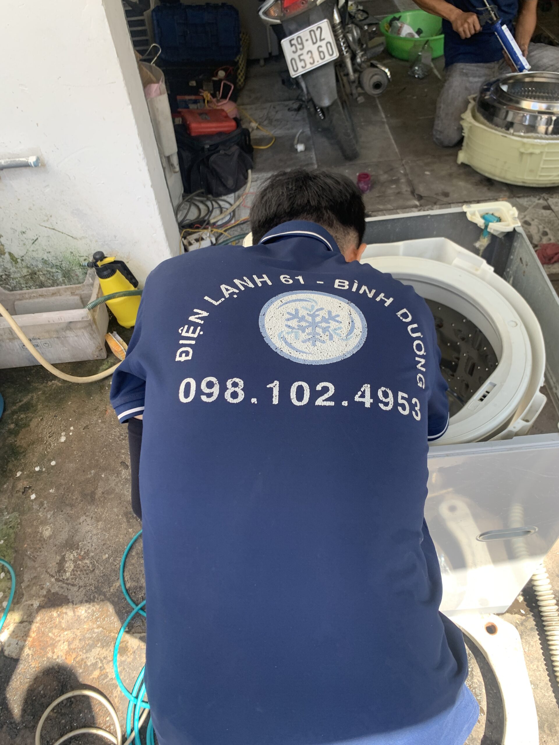 Xịt sạch mảng bám xà phòng lâu ngày trên chảng ba máy giặt cho khách hàng phường Đông Hòa.