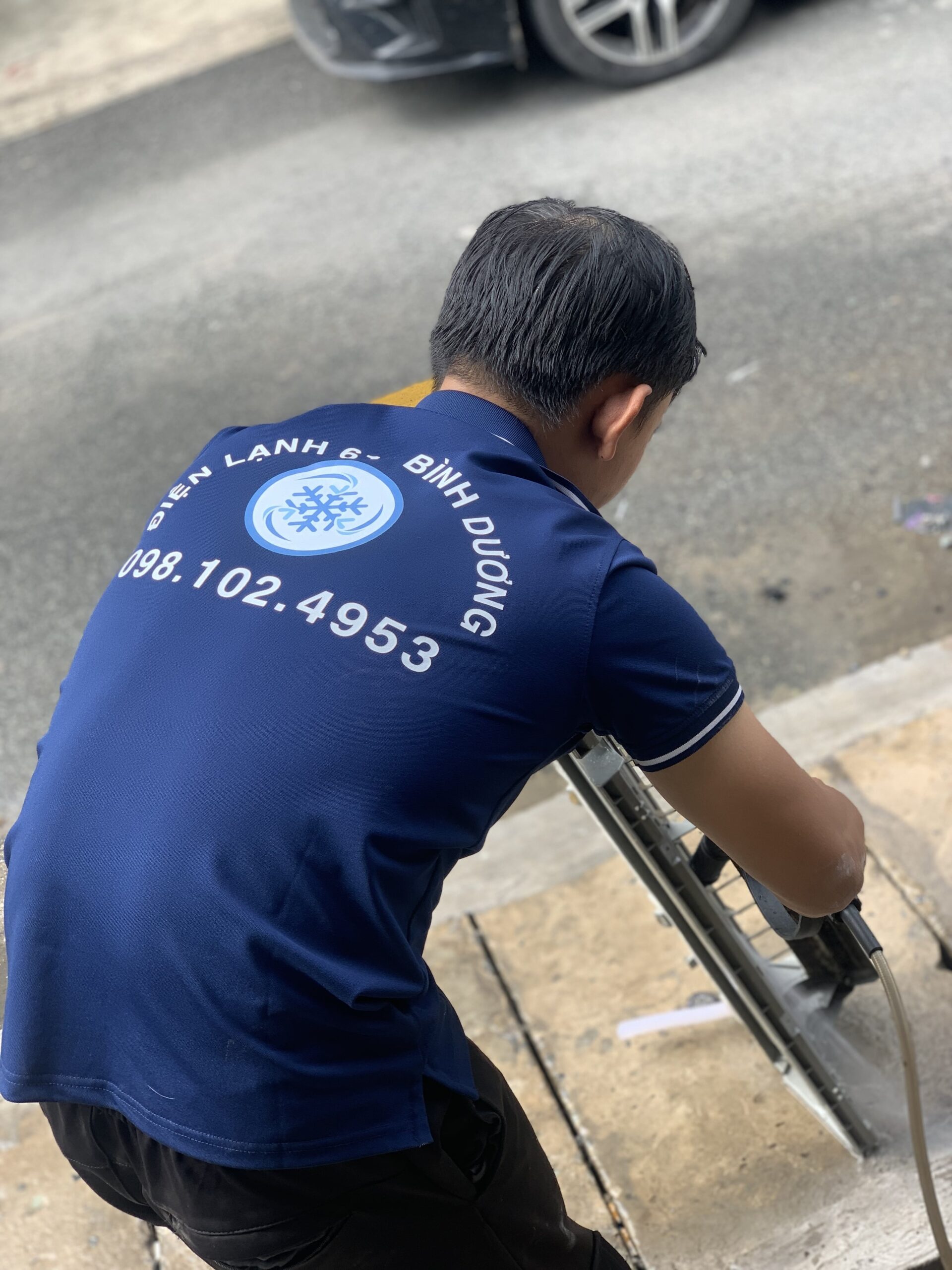 Thợ của Điện Lạnh 61 đang thực hiện dịch vụ vệ sinh điều hòa chuyên nghiệp tại nhà khách hàng ở Đông Hòa, Dĩ An