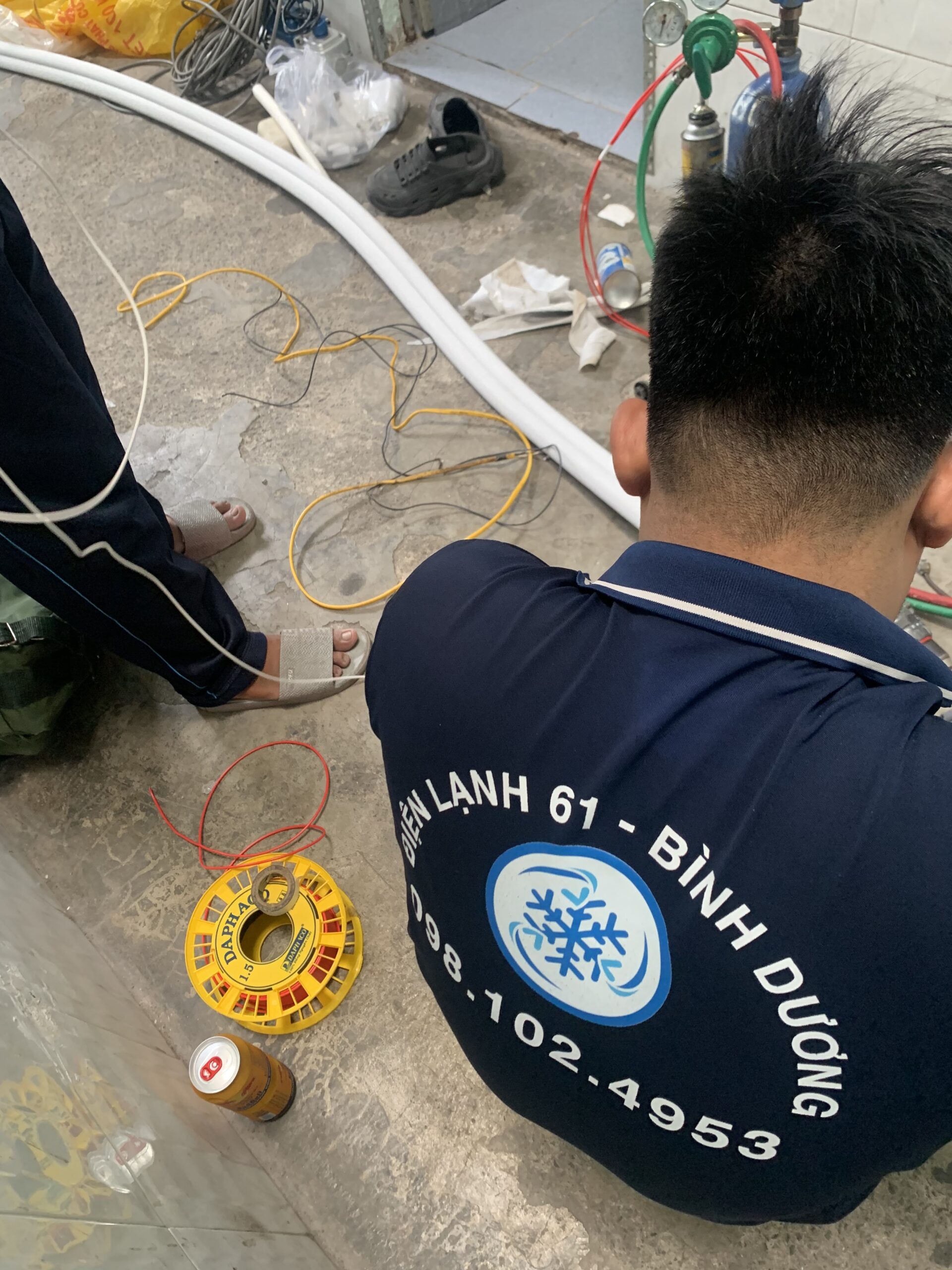 Chuyên viên Điện lạnh 61 đang kiểm tra và sửa chữa bo mạch máy lạnh, một dịch vụ chuyên sâu tại Bình Hòa