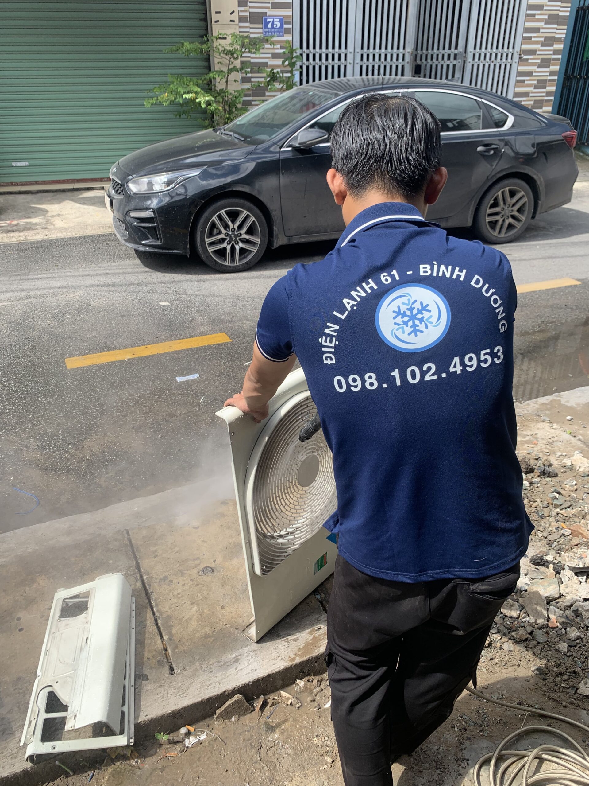 Kỹ thuật viên Điện Lạnh 61 đang xịt rửa dàn lạnh bằng máy bơm áp lực tại nhà ở Linh Xuân
