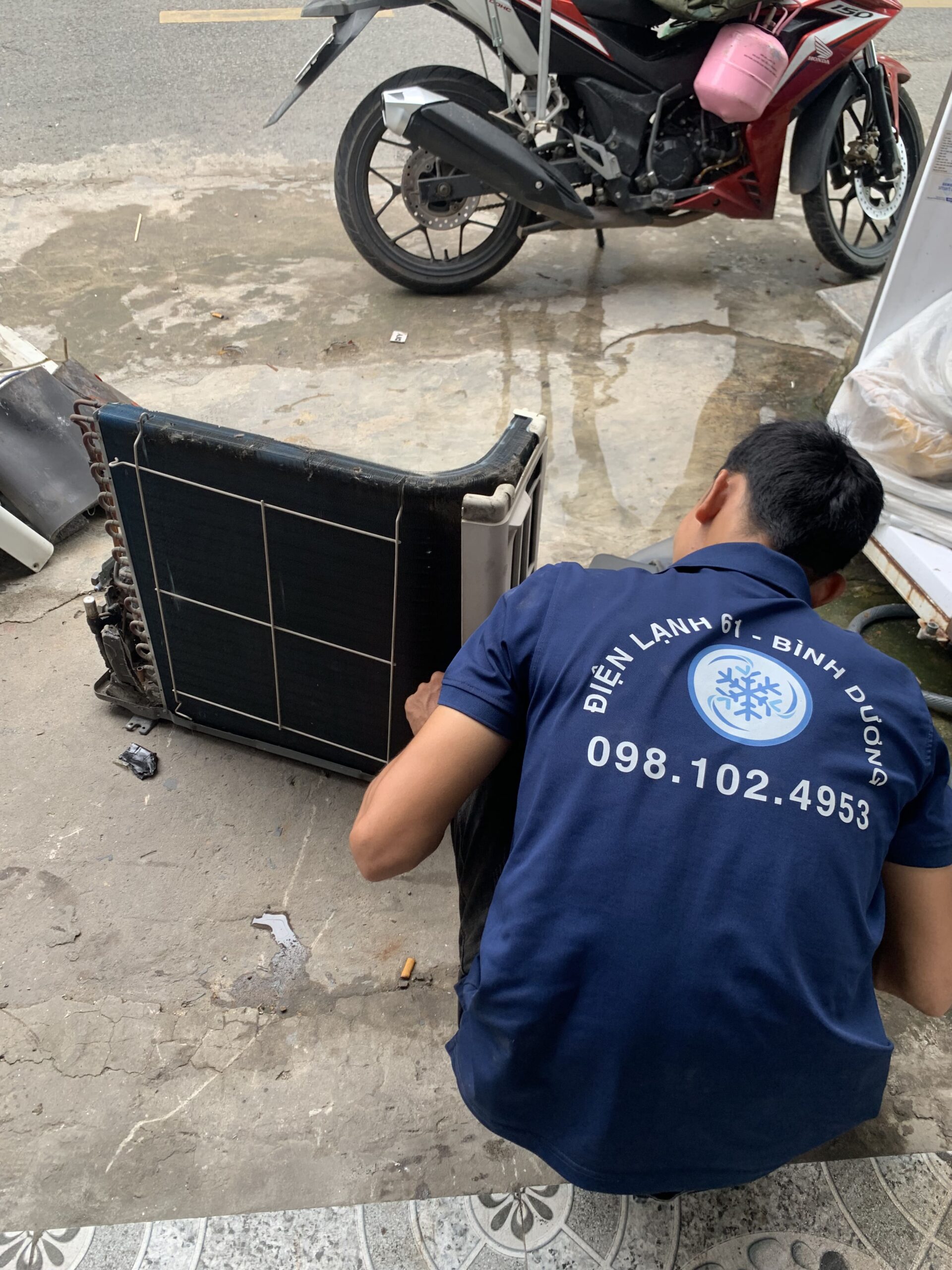 Kỹ thuật viên Điện Lạnh 61 với hơn 5 năm kinh nghiệm đang sửa chữa máy lạnh Inverter tại Thuận Giao