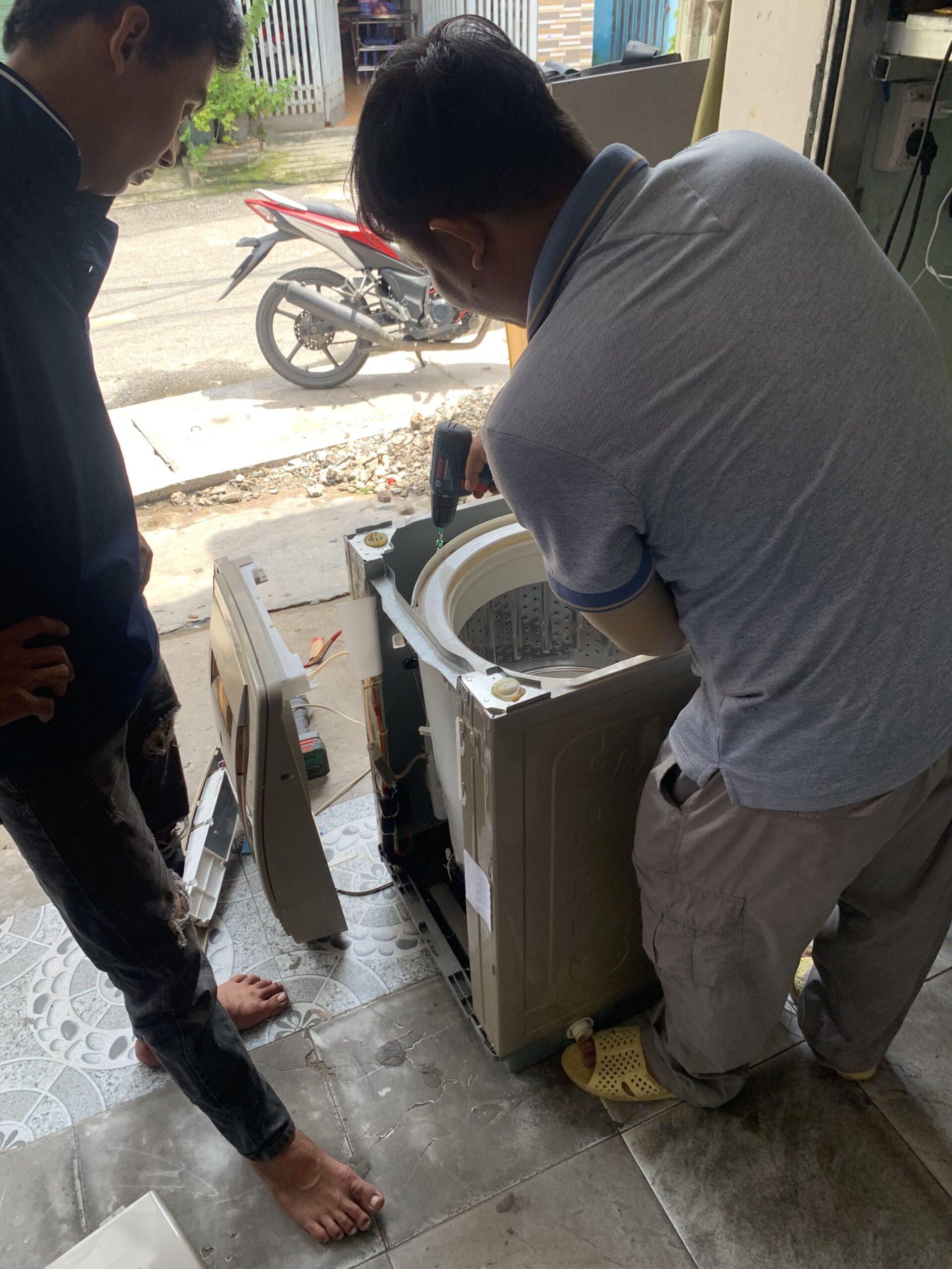 Kỹ thuật viên tháo rời lồng giặt để làm sạch toàn diện. Kỹ thuật viên tháo rời lồng giặt để làm sạch toàn diện.