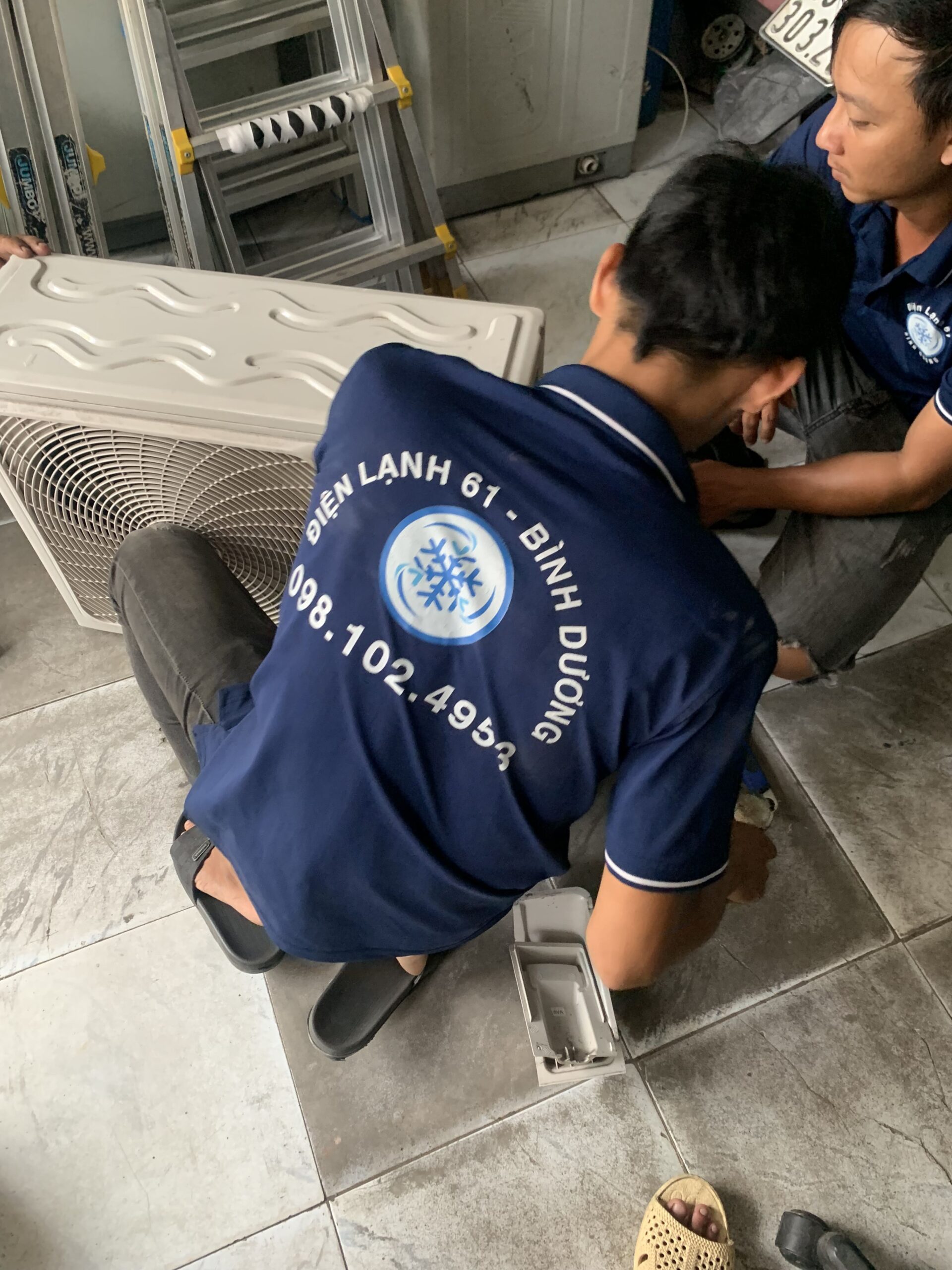 Thợ của Điện lạnh 61 đang làm sạch sâu dàn nóng điều hòa, giúp máy hoạt động hiệu quả hơn tại khu vực Phú Lợi