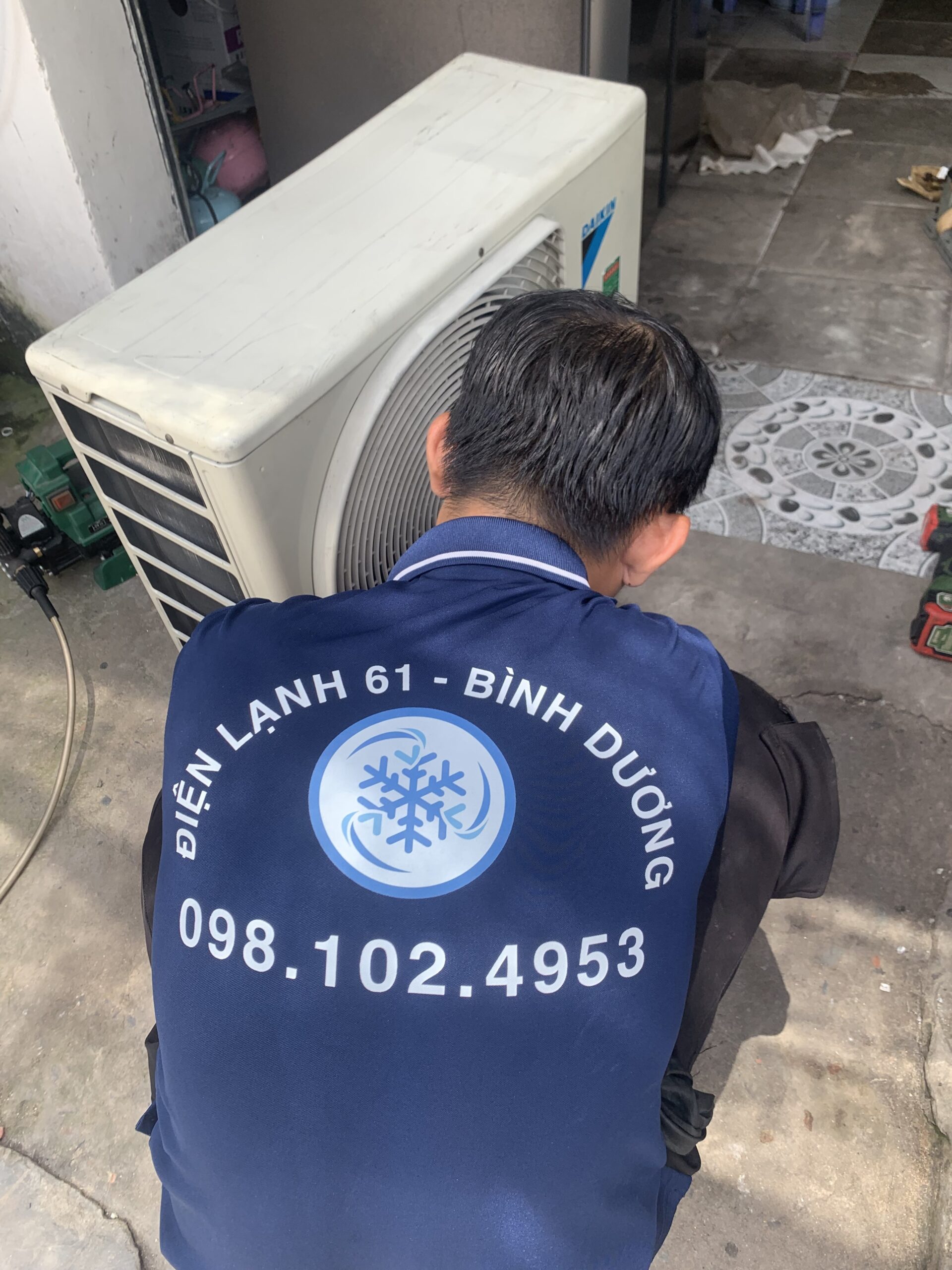 Thợ của Điện lạnh 61 đang nạp gas và sửa cục nóng máy lạnh tại phường Bình Hòa
