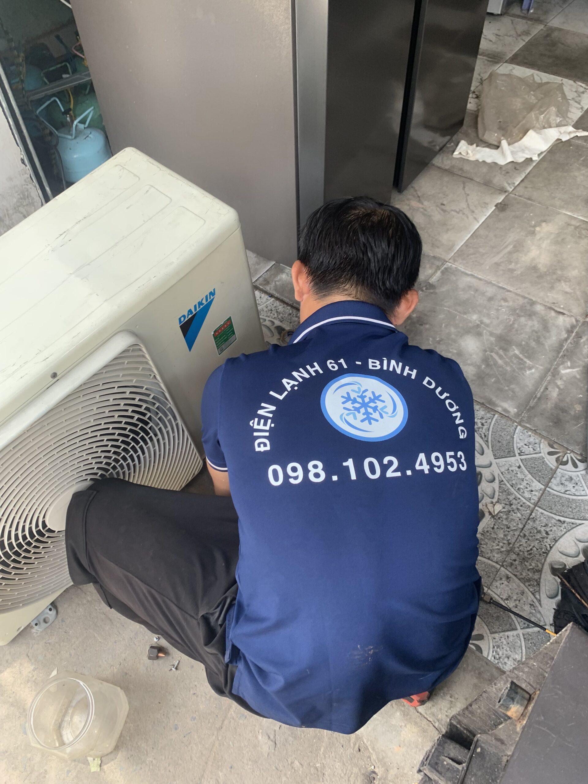 Thợ đang cẩn thận làm sạch lưới lọc bụi bẩn của máy lạnh tại một căn hộ ở Linh Xuân