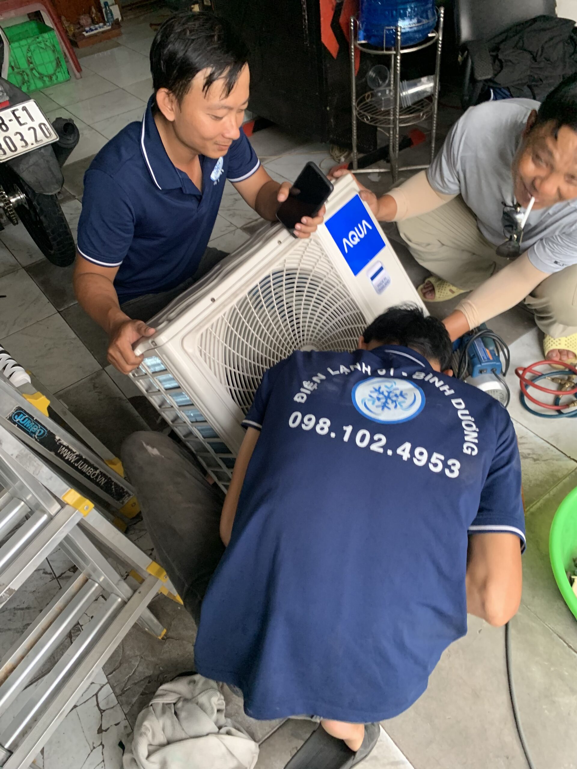 Thợ đang cẩn thận tháo dỡ máy lạnh để di dời tại một căn hộ ở Phú Lợi, Thủ Dầu Một.