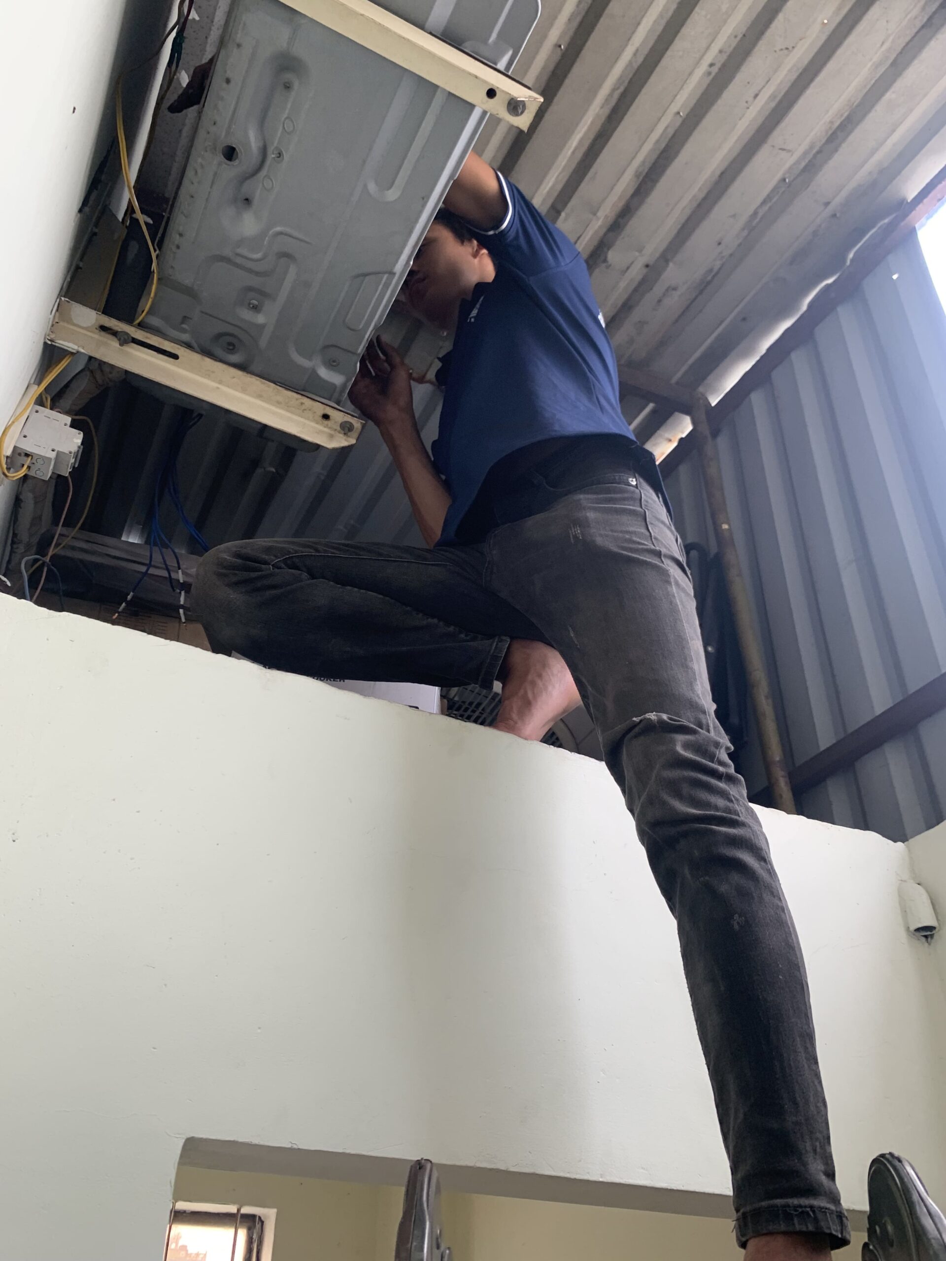 Thợ đang cẩn thận tháo dỡ máy lạnh để di dời tại một căn nhà ở Tam Bình, Thủ Đức.