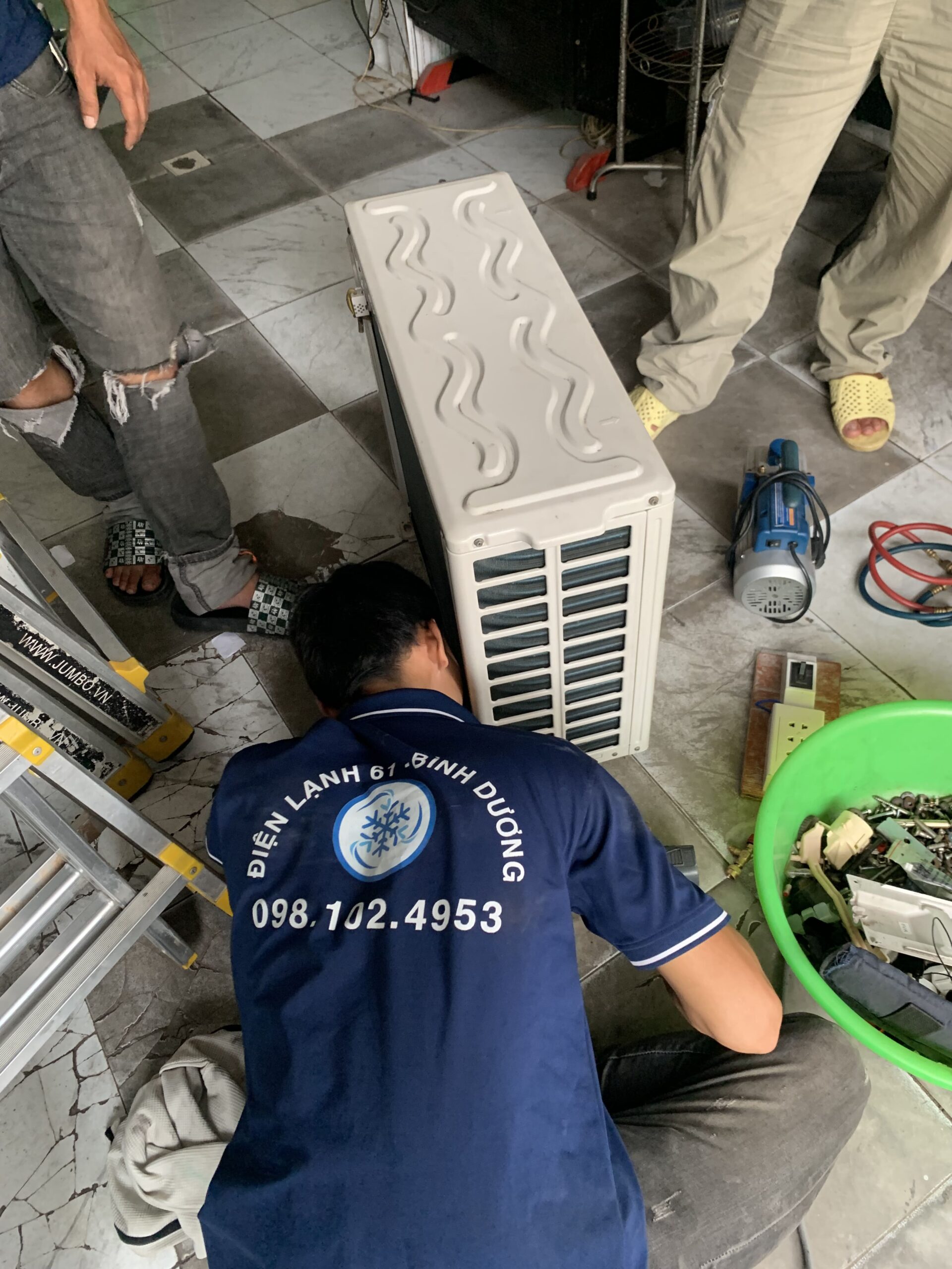Thợ đang kiểm tra và bơm gas máy lạnh trong quá trình vệ sinh tại Linh Xuân.