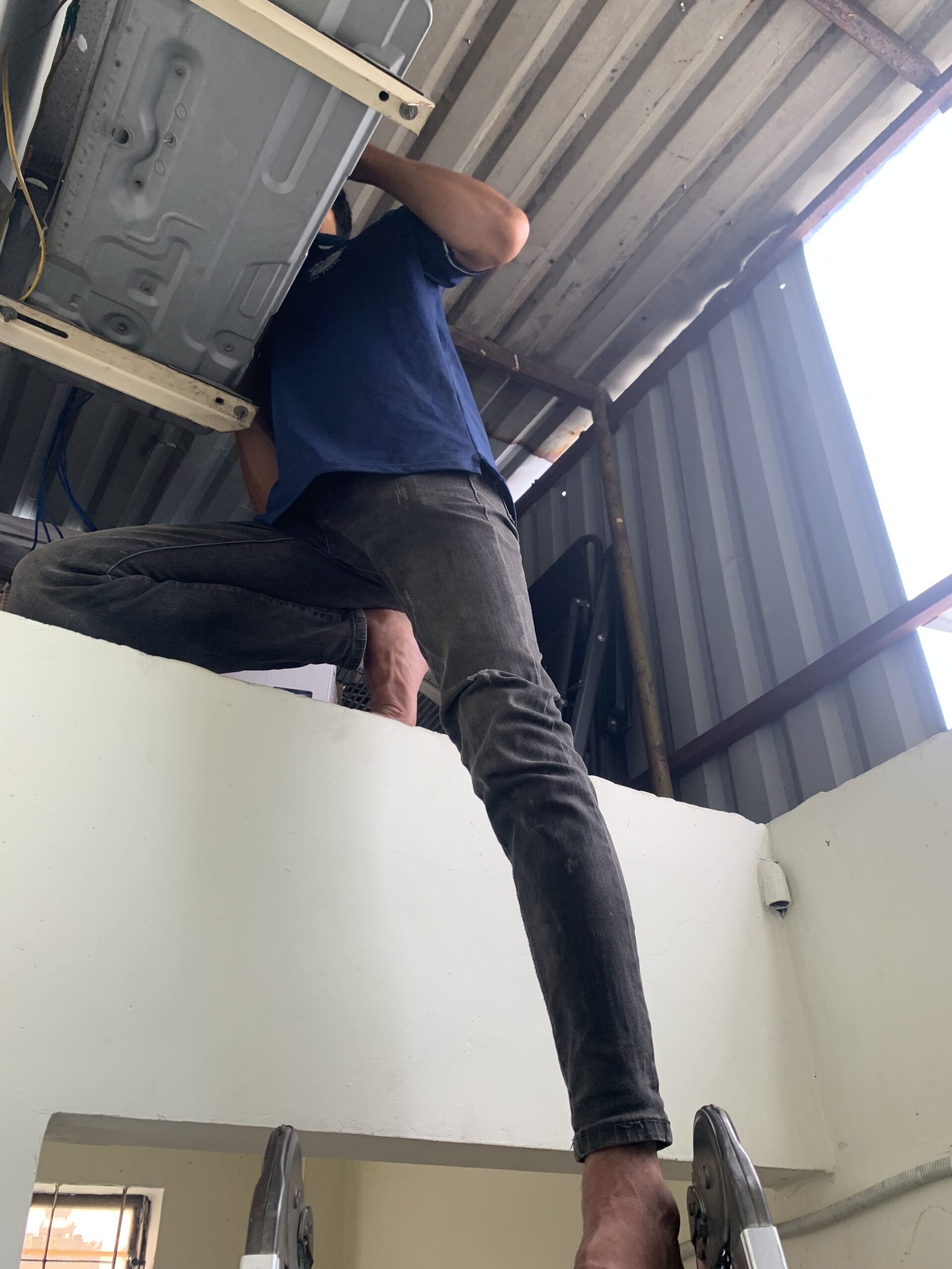Thợ đang kiểm tra và xử lý sự cố ở dàn nóng máy lạnh tại một tòa nhà ở Linh Xuân