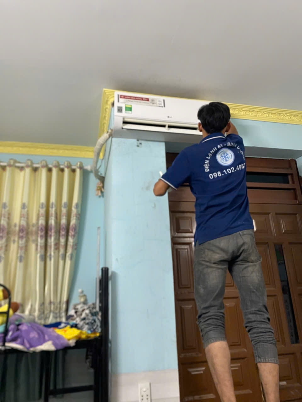 Thợ rửa máy lạnh tại phường Bình Hòa dùng khăn bọc kín bo mạch điện tử để chống vô nước.