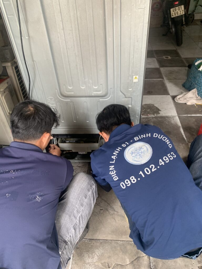 Thợ sửa tủ lạnh tại nhà Phú Lợi đang kiểm tra block máy nén cho khách hàng
