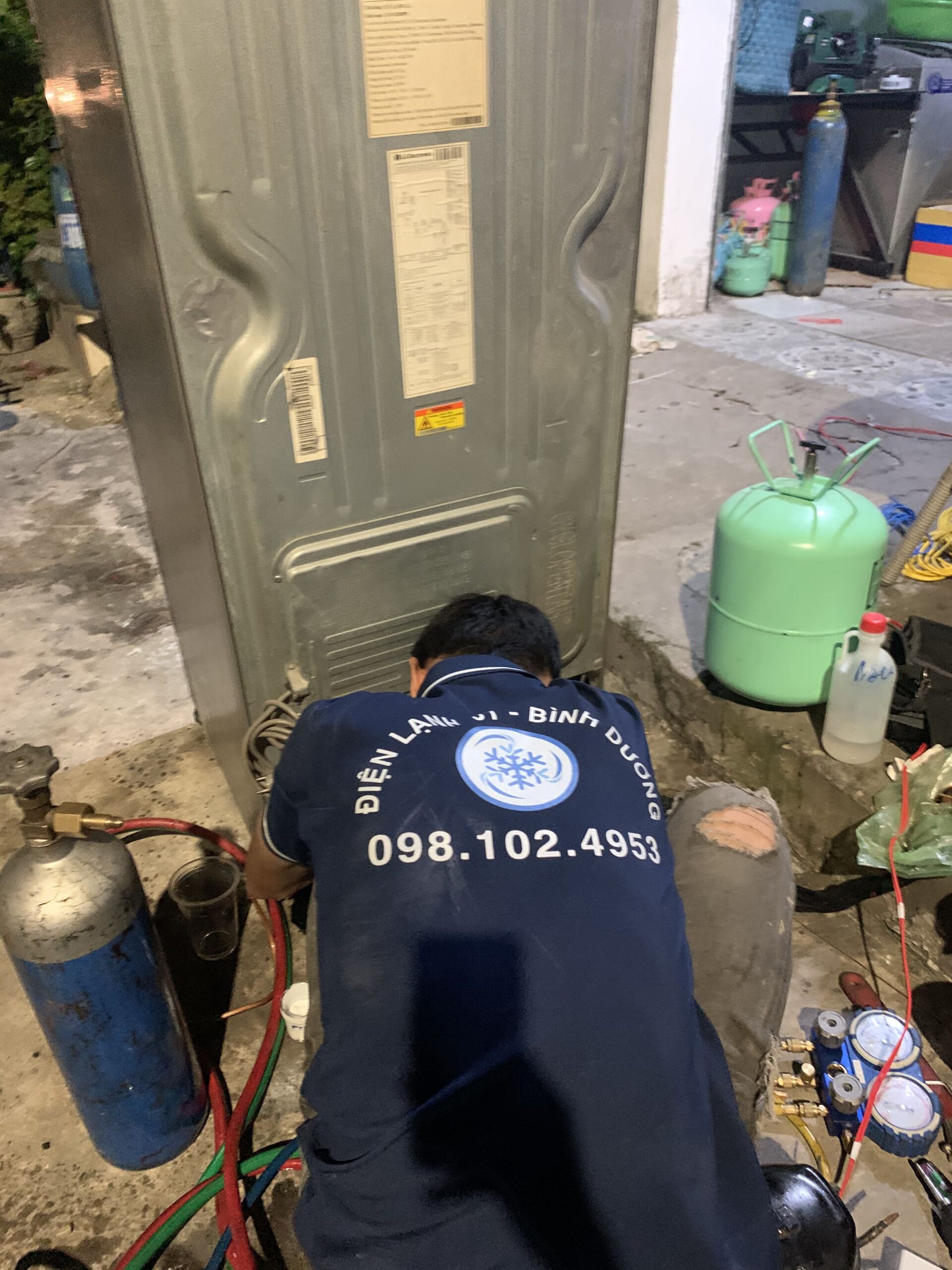 Nhân viên Điện Lạnh 61 đang nạp gas cho tủ lạnh tại Bình Hòa, đảm bảo đúng kỹ thuật