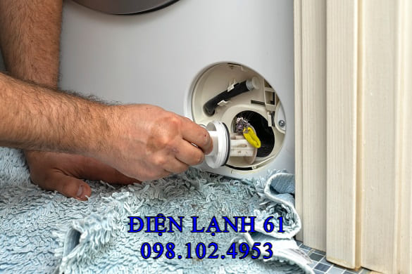 Một bộ lọc rác của máy giặt được lấy ra, chứa đầy xơ vải và cặn bẩn