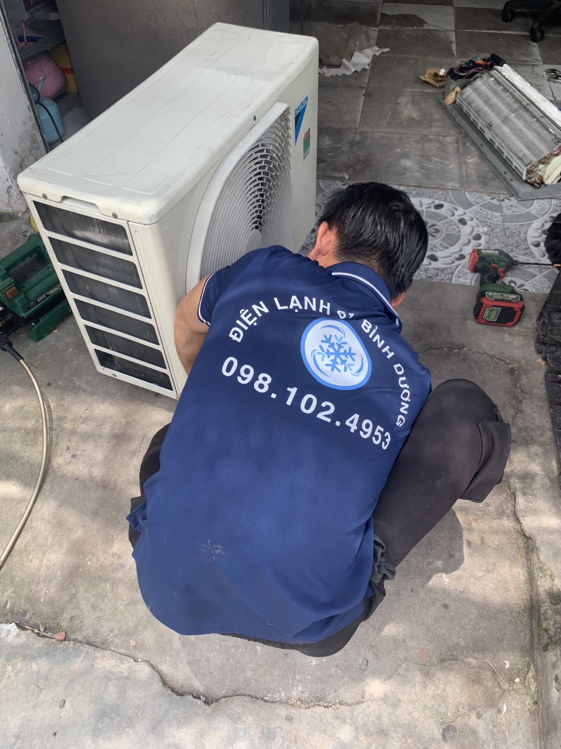 Kỹ thuật viên Điện Lạnh 61 đang tiến hành vệ sinh máy lạnh tại một căn hộ ở phường Bình Hòa