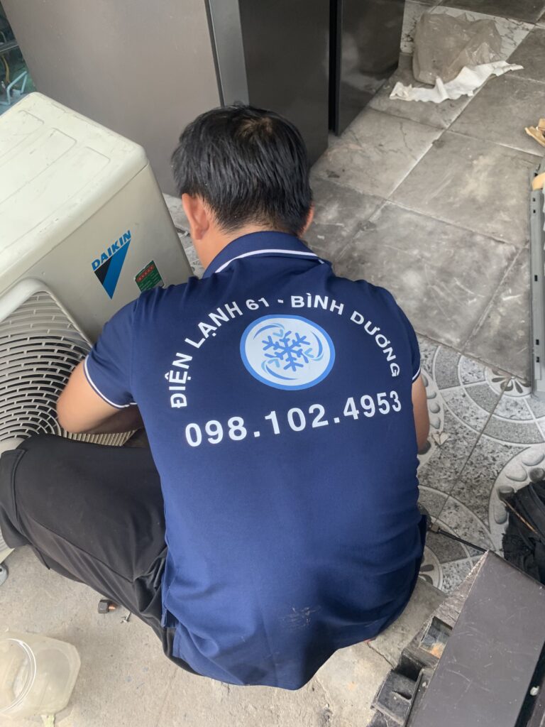 Kỹ thuật viên đang xịt rửa dàn lạnh máy lạnh treo tường.