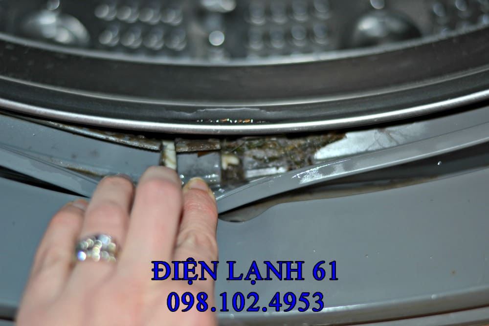 Cận cảnh nấm mốc đen và cặn bẩn tích tụ lâu ngày trên gioăng cao su cửa máy giặt LG lồng ngang.