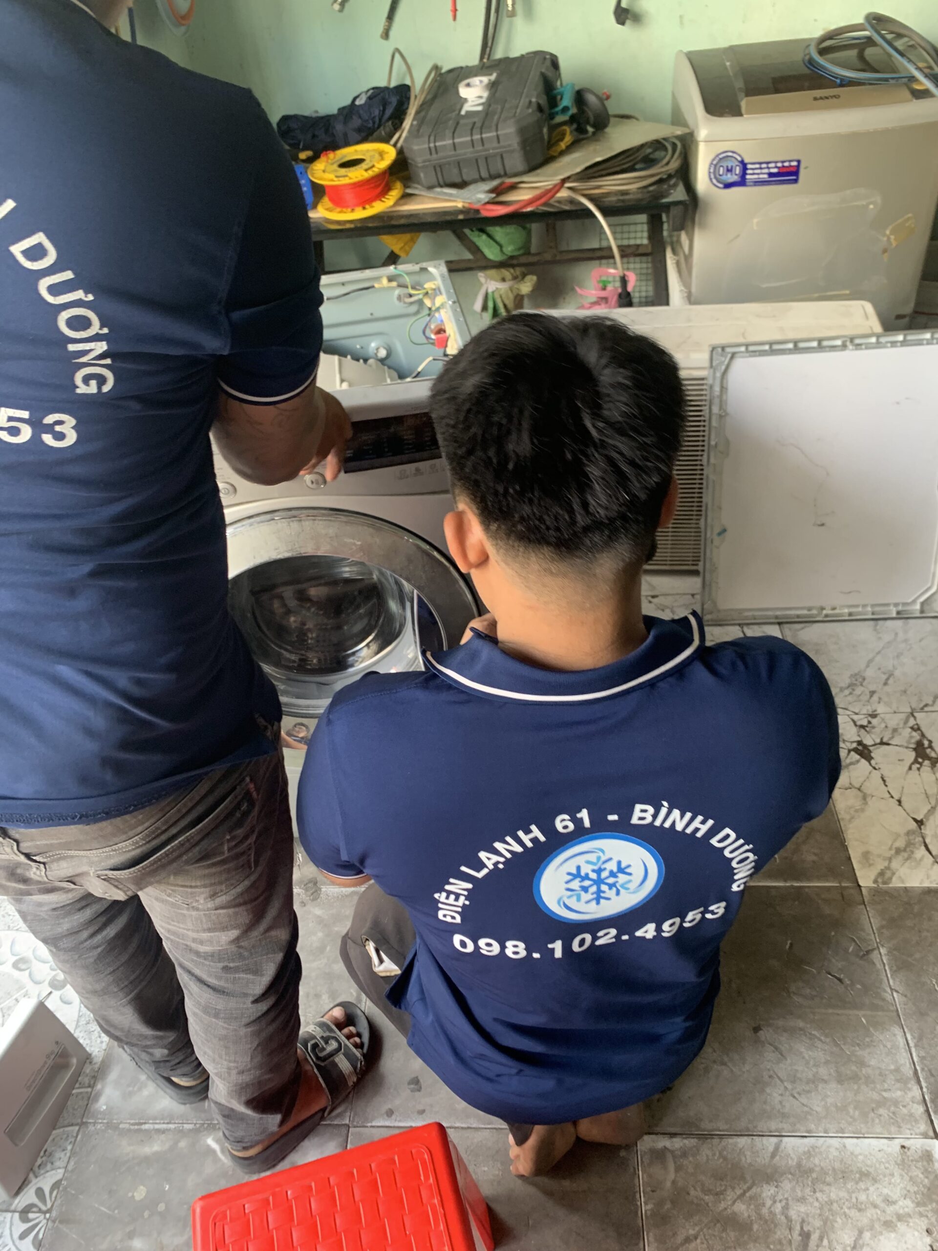 Kỹ thuật viên Điện Lạnh 61 đang thực hiện dịch vụ vệ sinh tháo lồng máy giặt chuyên sâu tại nhà khách hàng khu vực Dĩ An, Thuận An.
