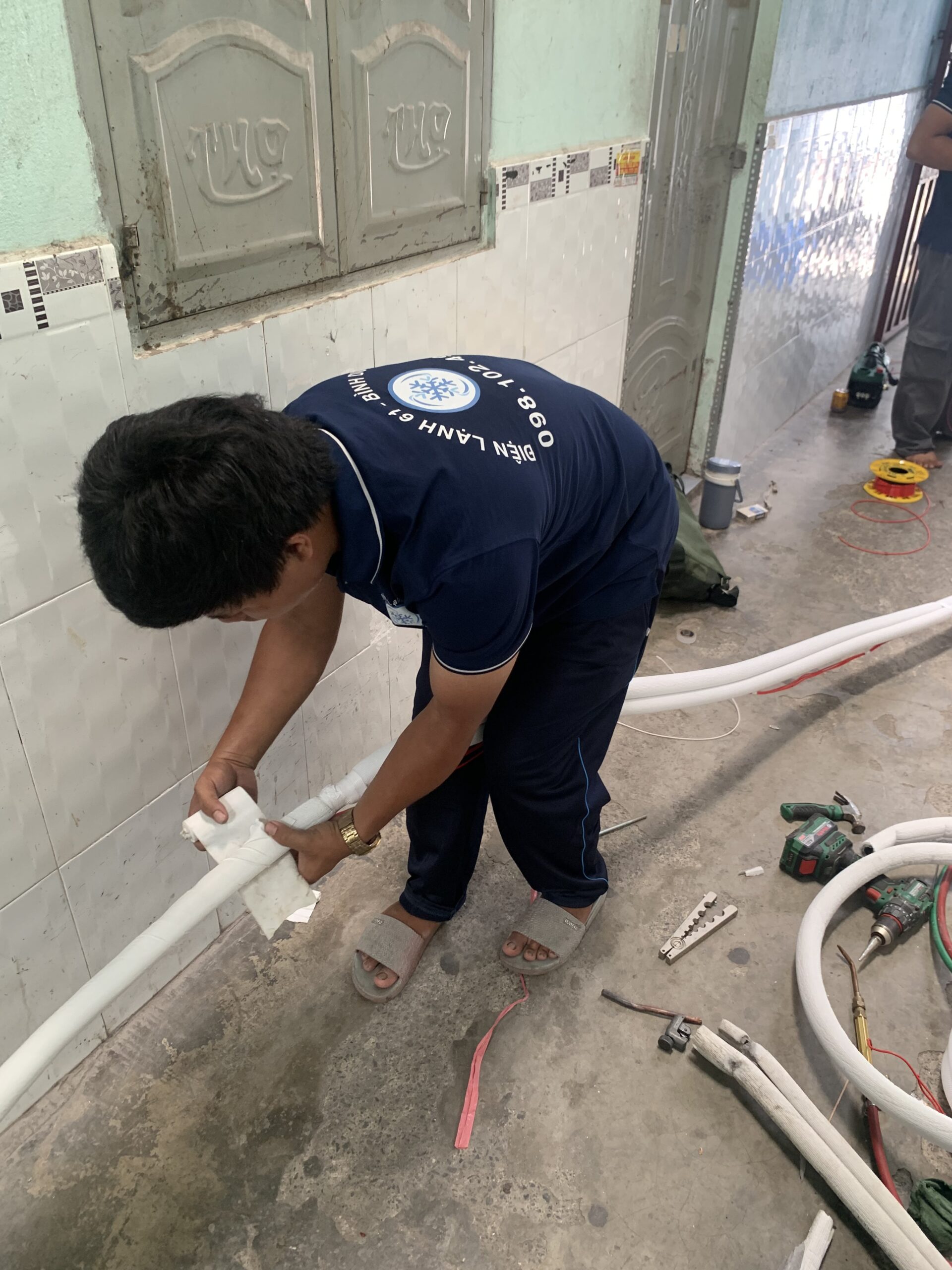 Quấn lại băng cuốn xi cách nhiệt bảo vệ đường ống đồng sau khi khắc phục lỗi rò rỉ.