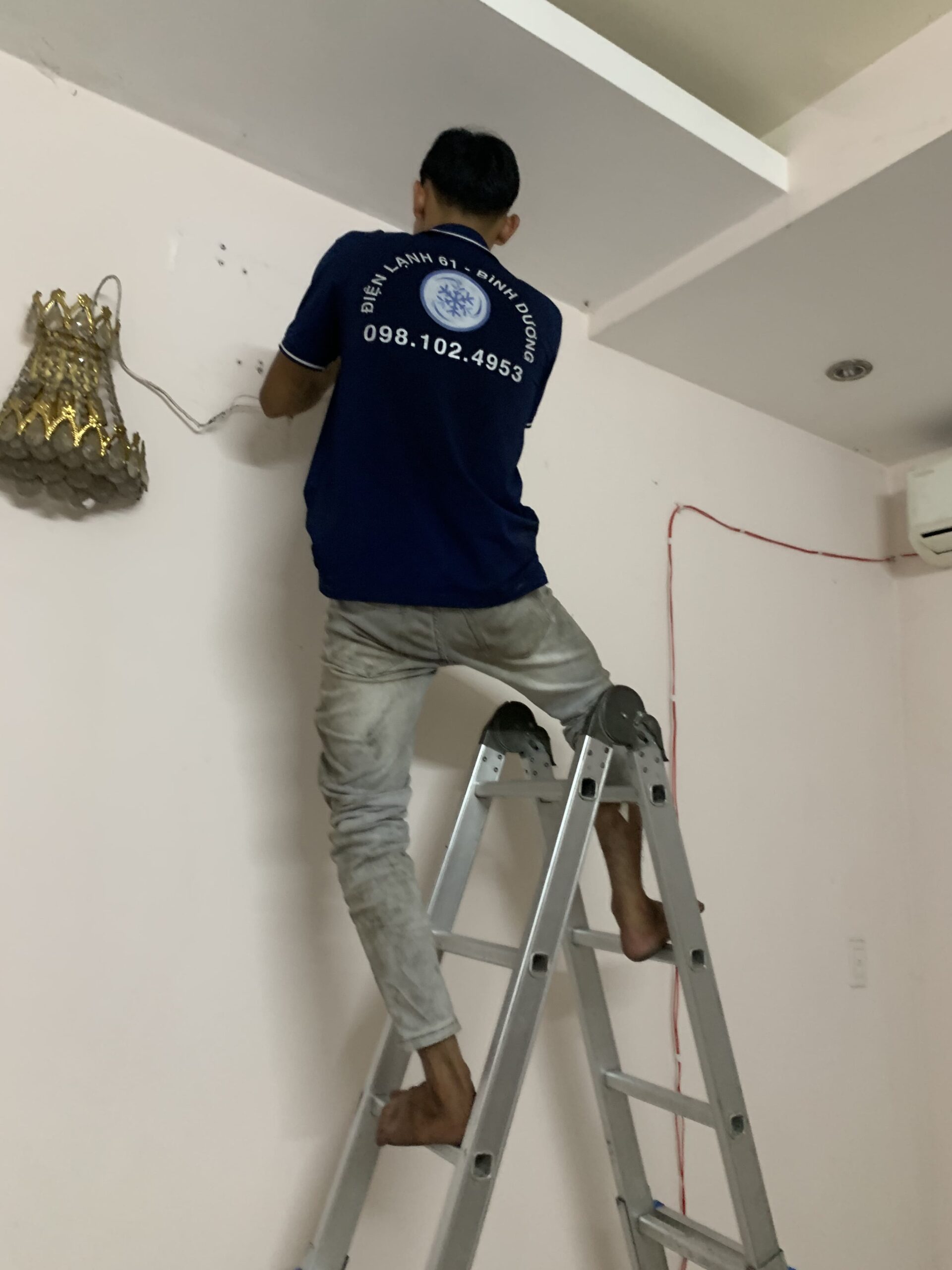 Thợ bơm gas máy lạnh Thủ Dầu Một kiểm tra thông số kỹ thuật và loại gas in trên thân máy.