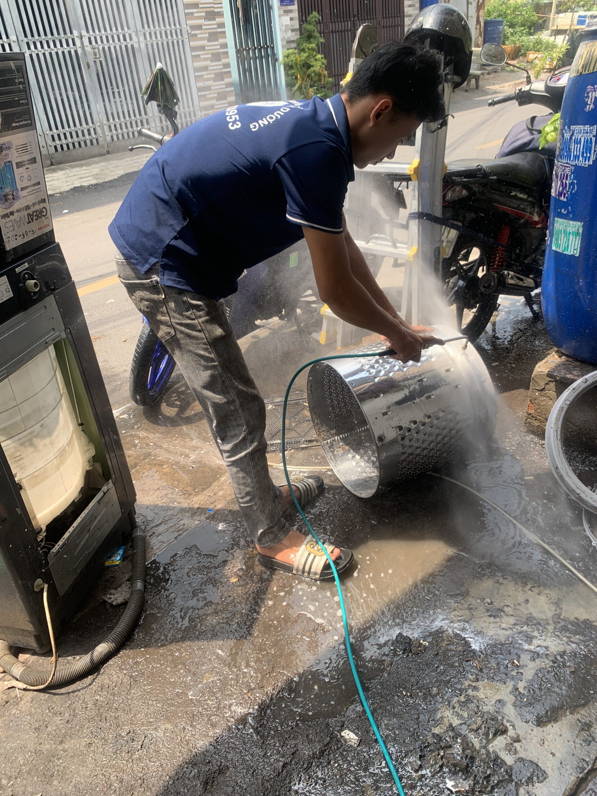 Thợ kỹ thuật của Điện Lạnh 61 đang vệ sinh máy giặt chuyên sâu tại nhà khách hàng Dĩ An