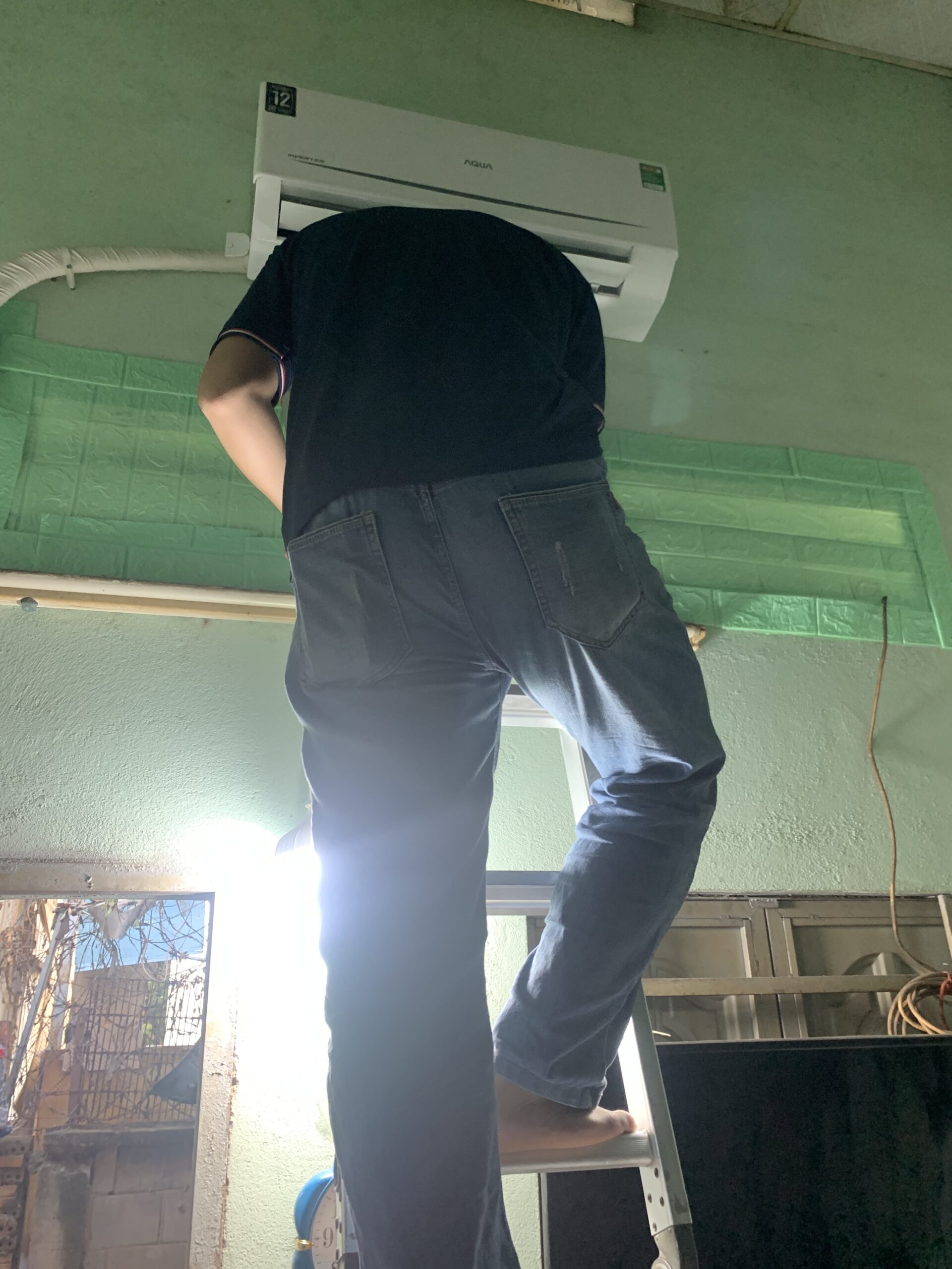 Kỹ thuật viên đang dùng đồng hồ chuyên dụng để kiểm tra gas máy lạnh, đảm bảo máy hoạt động đủ công suất.