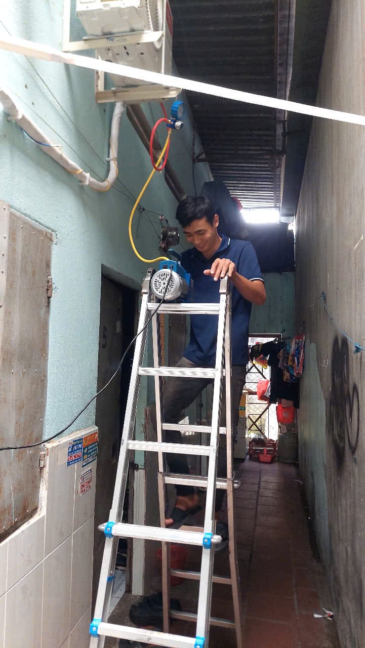 Kỹ thuật viên đang sử dụng đồng hồ chuyên dụng để kiểm tra và đo áp suất gas máy lạnh sau khi bảo dưỡng