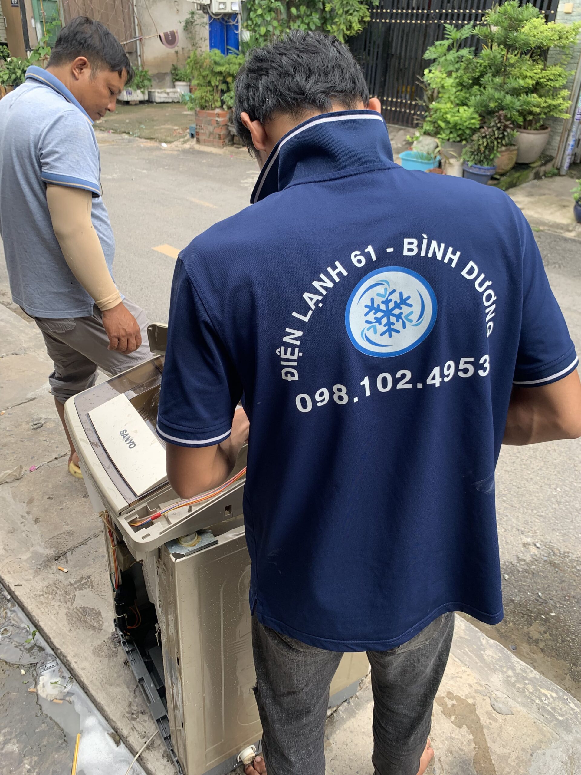 Thợ sửa máy giặt tại Dĩ An của Điện Lạnh 61 đang kiểm tra lỗi chảy nước cho khách hàng