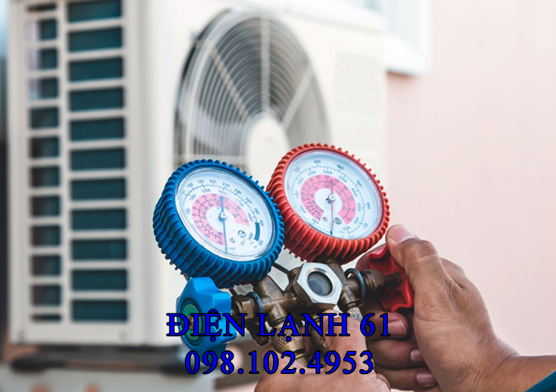 Kỹ thuật viên Điện Lạnh 61 đang cầm đồng hồ đo gas kiểm tra cục nóng