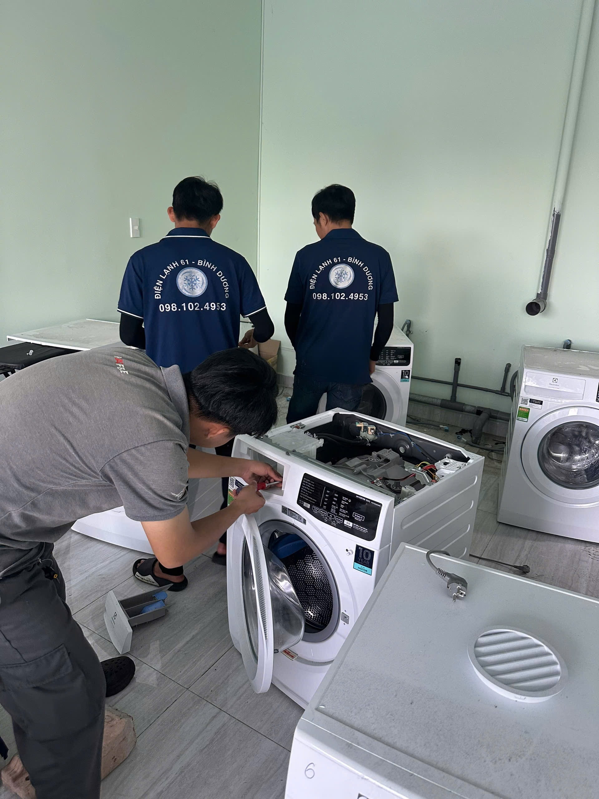 Kỹ thuật viên Điện Lạnh 61 đang thay bơm xả máy giặt Electrolux cửa ngang tại Dĩ An