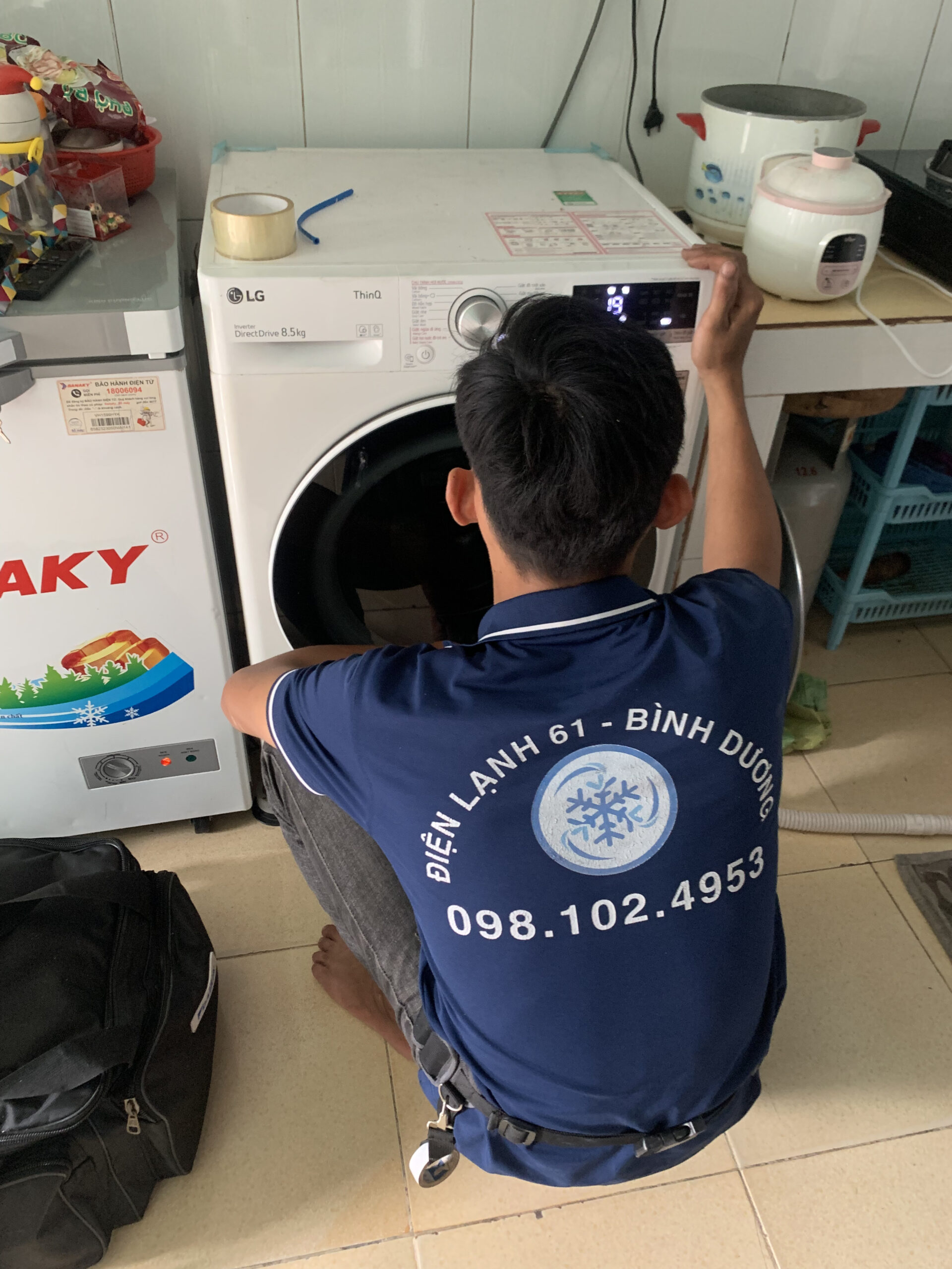 Kỹ thuật viên Điện Lạnh 61 đang thay công tắc cửa máy giặt LG tại Dĩ An